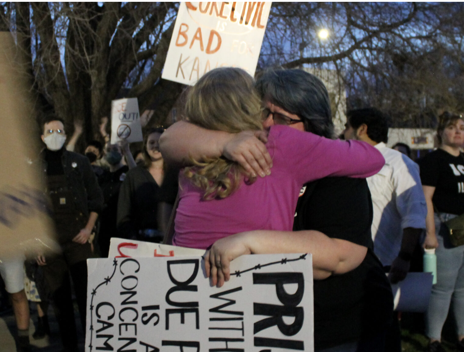  Protesters hug after learning they lost the fight to keep private prison CoreCivic from reopening in Leavenworth. The city commission voted 4 to 1 on March 10, 2026, to give the company a special use permit. (Photo by Grace Hills for the Kansas Reflector)