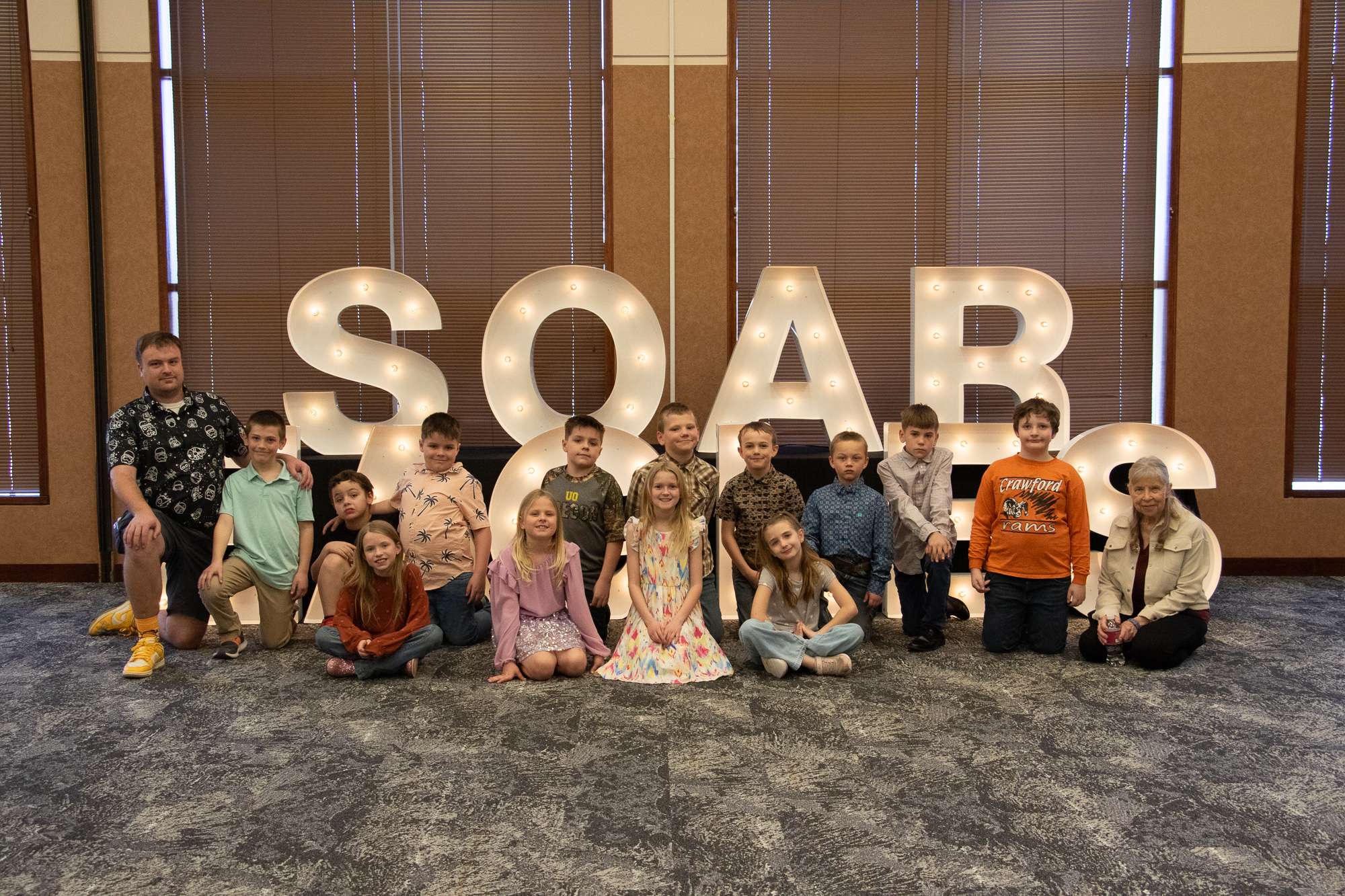 Crawford, Nebraska, third grade students pose March 4, 2026, in the Chadron State College Student Center with their teacher and CSC alum Brennann Jackson, left, and Western District History Day longtime supporter Moni Hourt, right. (Photo by Tena L. Cook/Chadron State College)