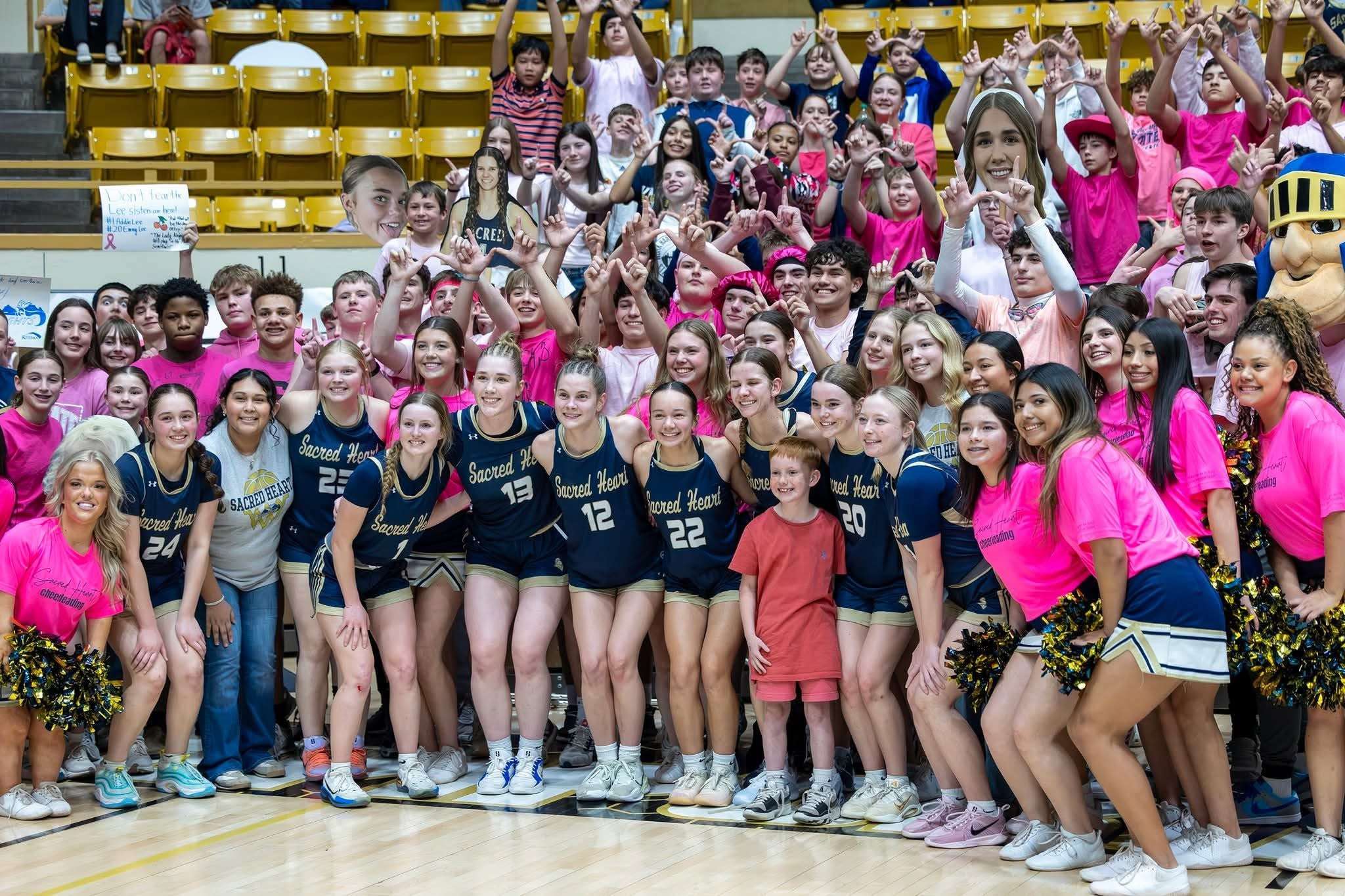 The Lady Knights celebrate a semifinal victory in Emporia with the Sacred Heart student section. Photo courtesy of Carl Hines.