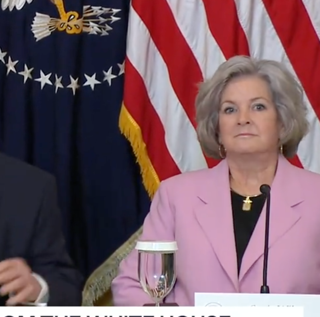Susie Wiles shown sitting next to President Trump during a Monday morning news conference-image from White House video
