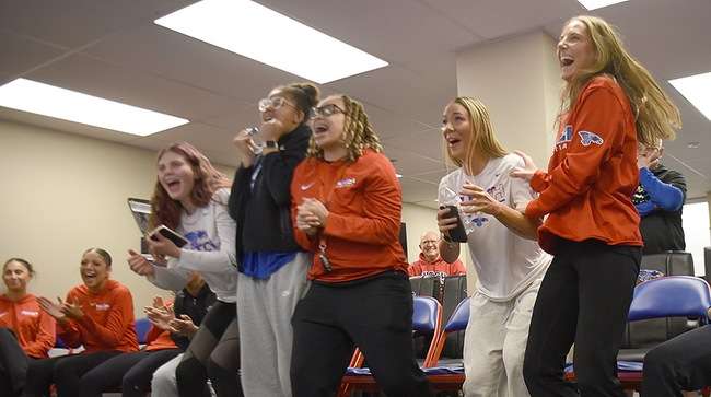 The Blue Dragon women's basketball team reacts after hearing its name on the NJCAA Selection Show on Monday at a watch party in the Club 1982 room. The Blue Dragons will be the No. 13-seed in the NJCAA Tournament and will play Williston State. (Steve Carpenter/Blue Dragon Sports Information)