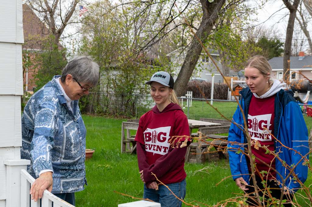 The Big Event volunteers chat with a Chadron community member before completing yard work, April 26, 2025, (Photo by Sydney Brown/Chadron State College).