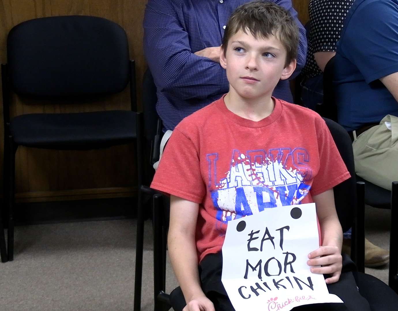 Noah Berges, 10, a Roosevelt Elementary School student, shows his support for the planned Chick-fil-A restaurant to Hays city commissioners during their March 19 work session. Photo by Becky Kiser/Hays Post