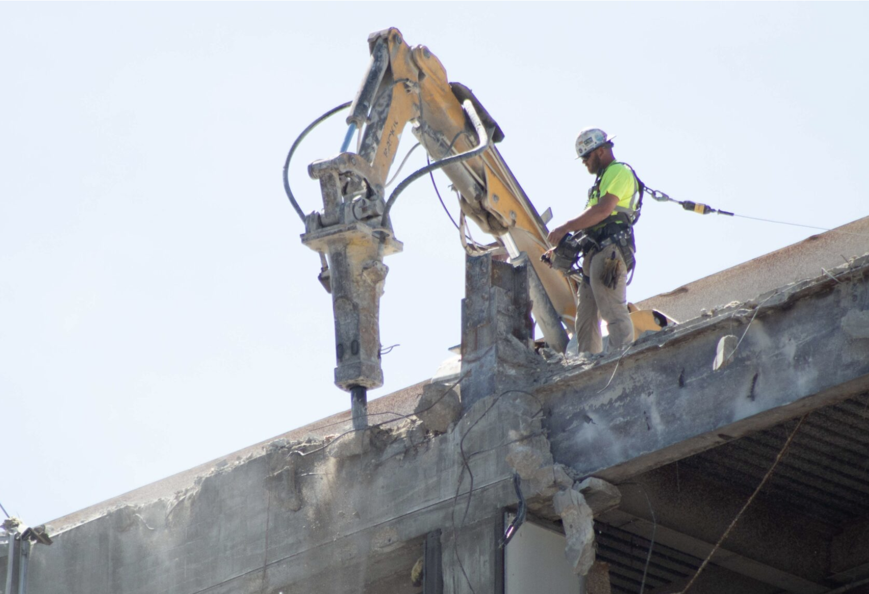 The Kansas Legislature passed a bill raising the ceiling for no-bid county construction projects and rejected a companion proposal repealing construction worker protections. A construction worker appears on Aug. 17, 2023, demolishing the former Docking State Office Building in downtown Topeka, Kansas. (Photo by Sam Bailey/Kansas Reflector)