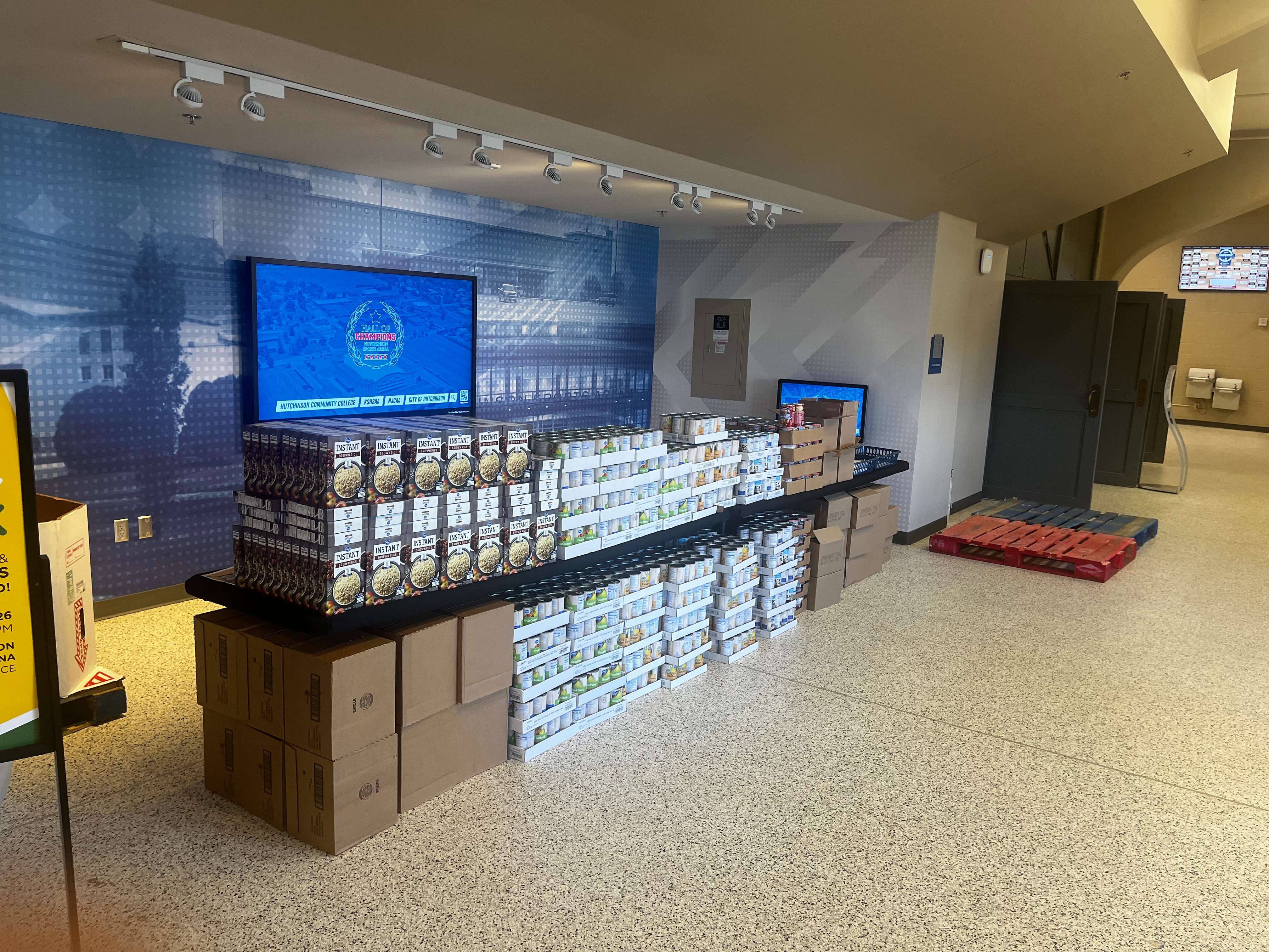 Shelf stable food awaits to be assembled into meal kits at the food pack event at the NJCAA Men's Div 1 National Basketball Tournament. (Hutch Post photo)