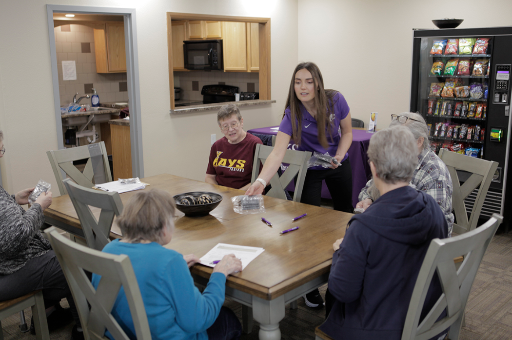 Karissa Frasier, a community health worker in K-State's Ellis County Extension office in Hays, hands out pedometers for participants in the Stay Strong, Stay Healthy class offered in Hays. Photo courtesy K-State Extension