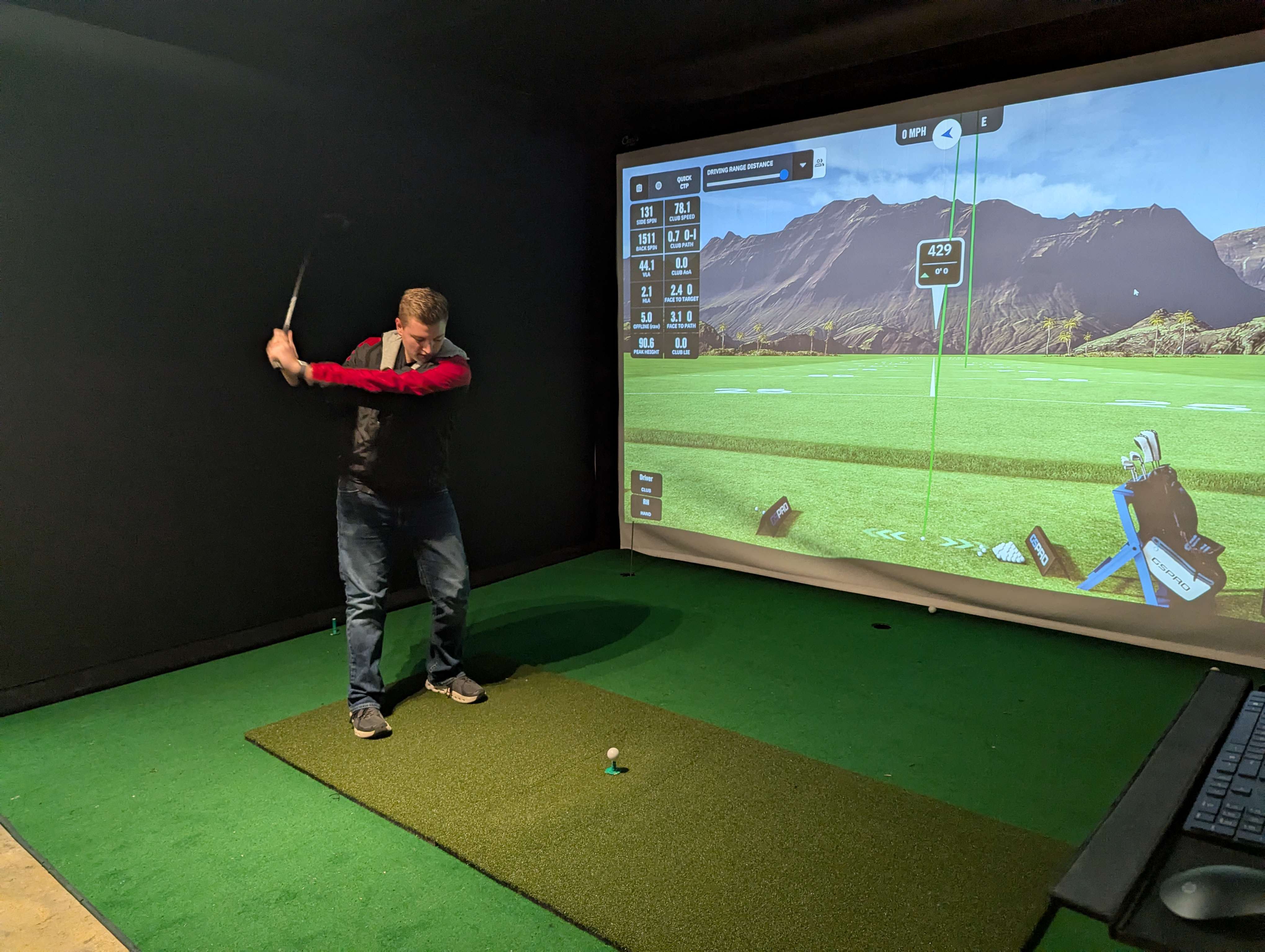 GBHS senior Keegan Roblyer steps up to the tee and prepares to swing inside the Panther Fieldhouse golf simulator, where the team has prepared for their spring season.