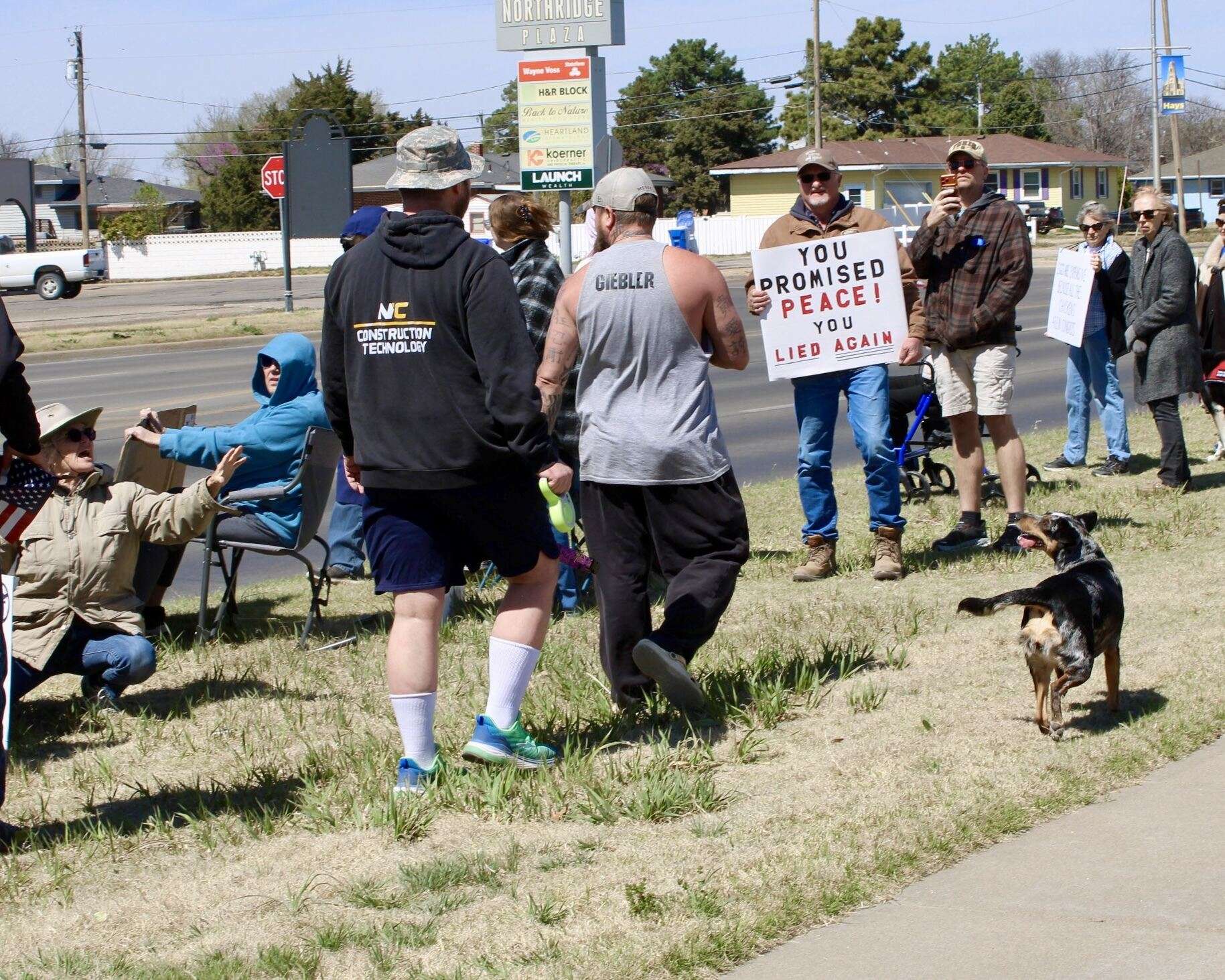 The unknown man in a gray shirt (right) shouting at protestors, with one of them following behind him (left). Photo by Tony Guerrero/Hays Post