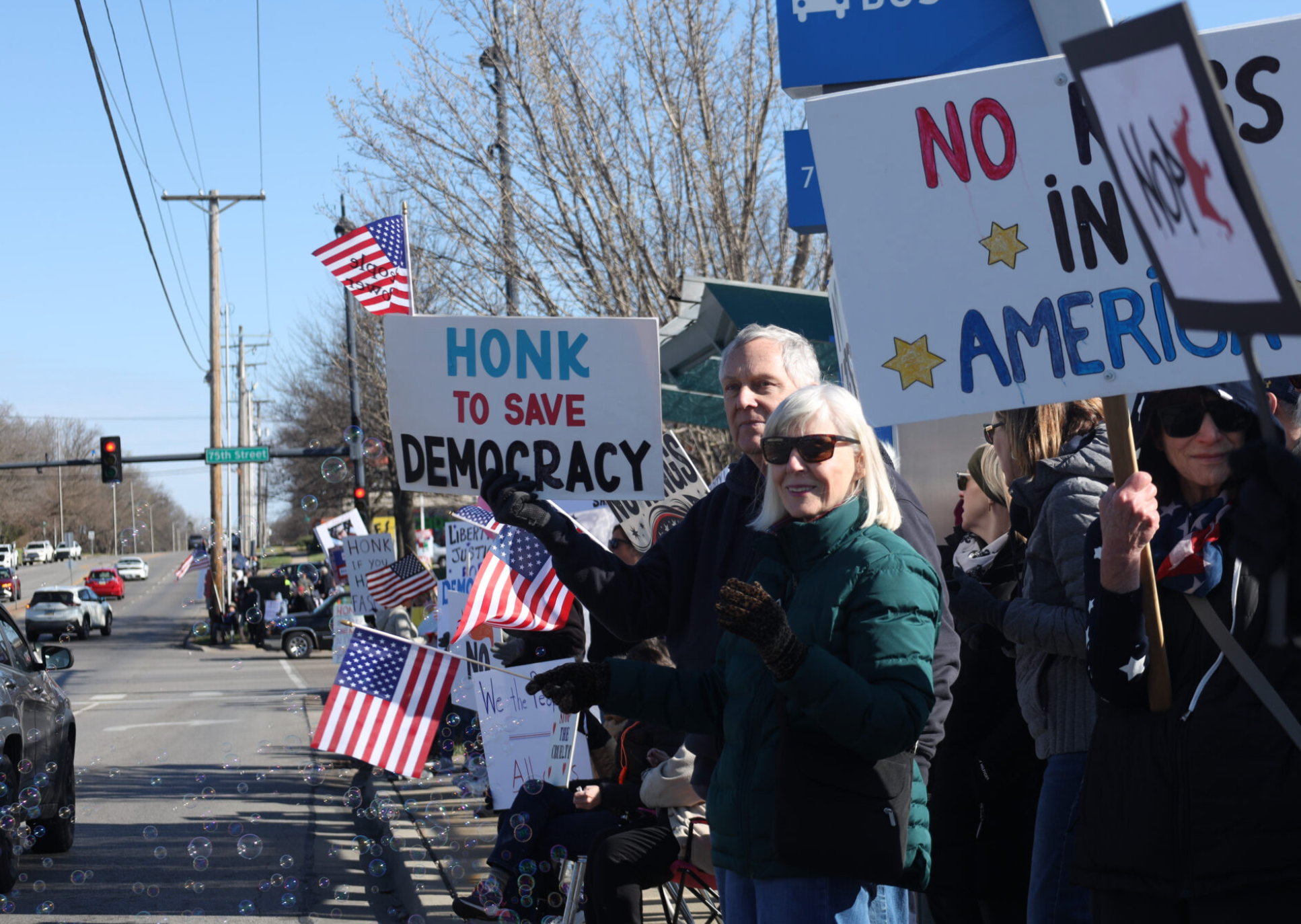 Protestors line up March 28, 2026, along a six-mile stretch of Metcalf Avenue as part of a No Kings rally in Johnson County. (Photo by Maya Smith for Kansas Reflector)