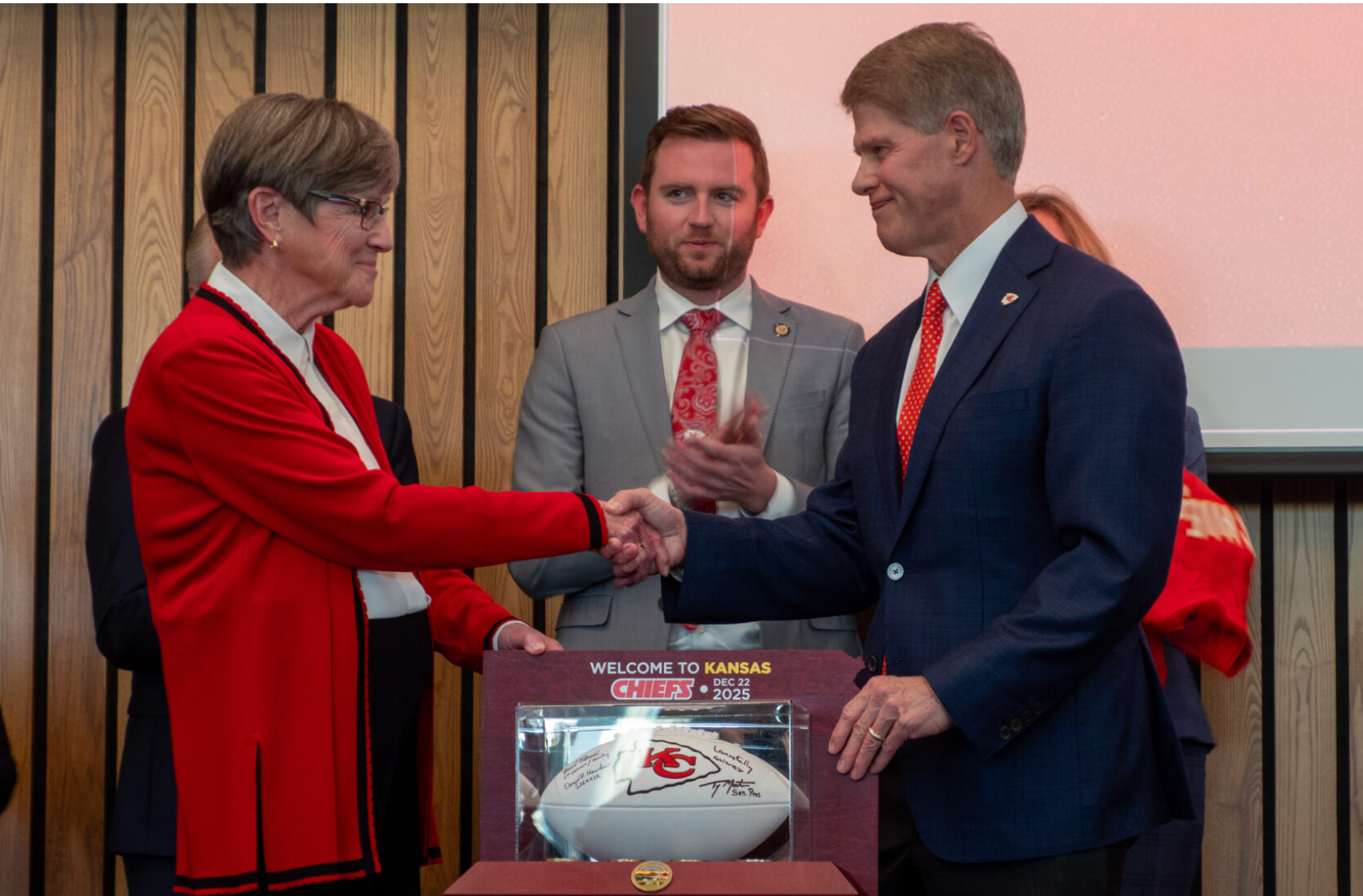  The multi billion dollar deal to lure the Kansas City Chiefs across the state line into Kansas requires a sports authority to oversee the project details. Gov. Laura Kelly and Clark Hunt shake hands after announcing the team’s move on Dec. 23, 2025, at the Docking State Office Building in Topeka, Kansas. (Photo by Anna Kaminski/Kansas Reflector)