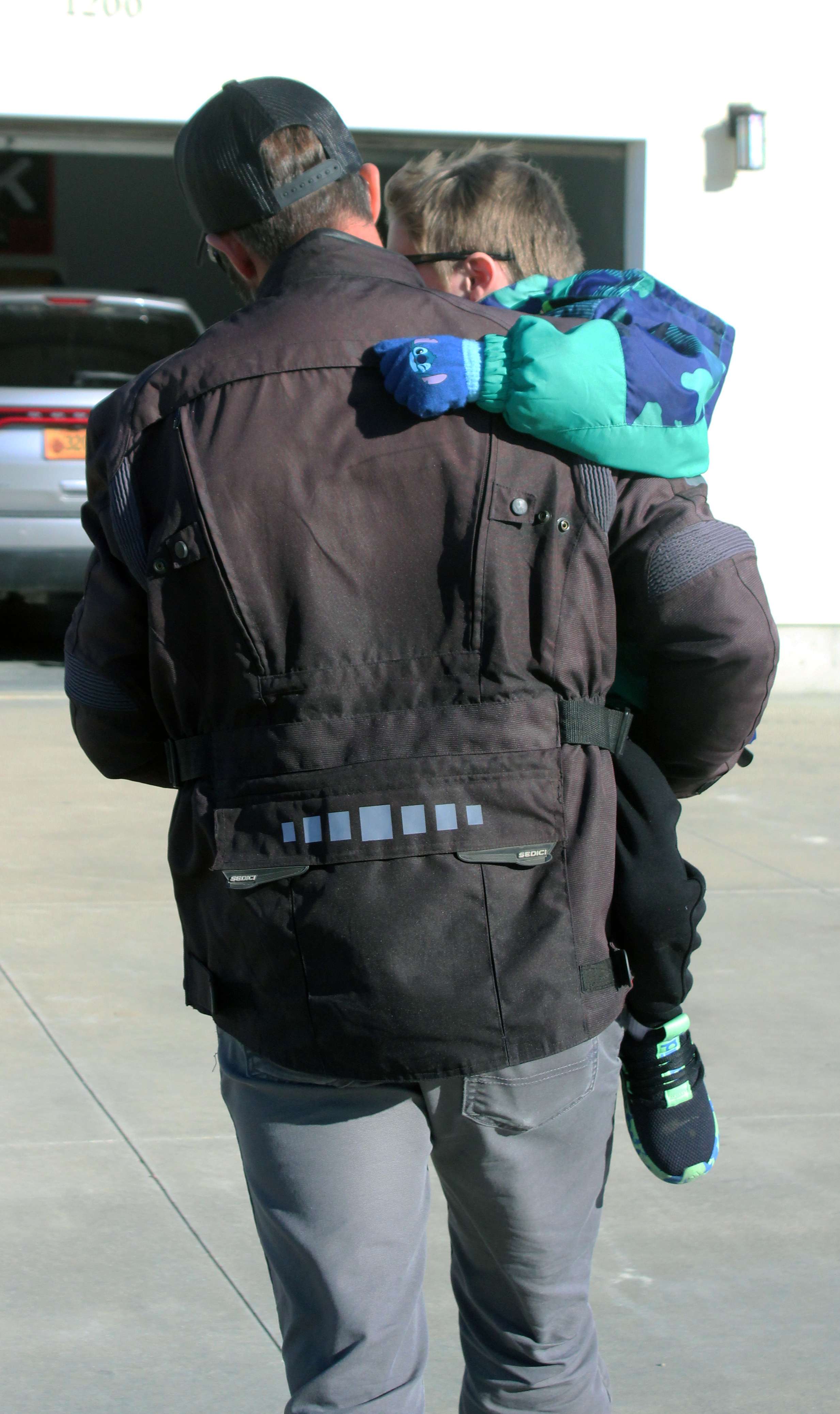 Dooley carries Brody. It is gradually becoming more difficult for Brody to walk. He eventually will be confined to a wheelchair. Photo by Cristina Janney/Hays Post