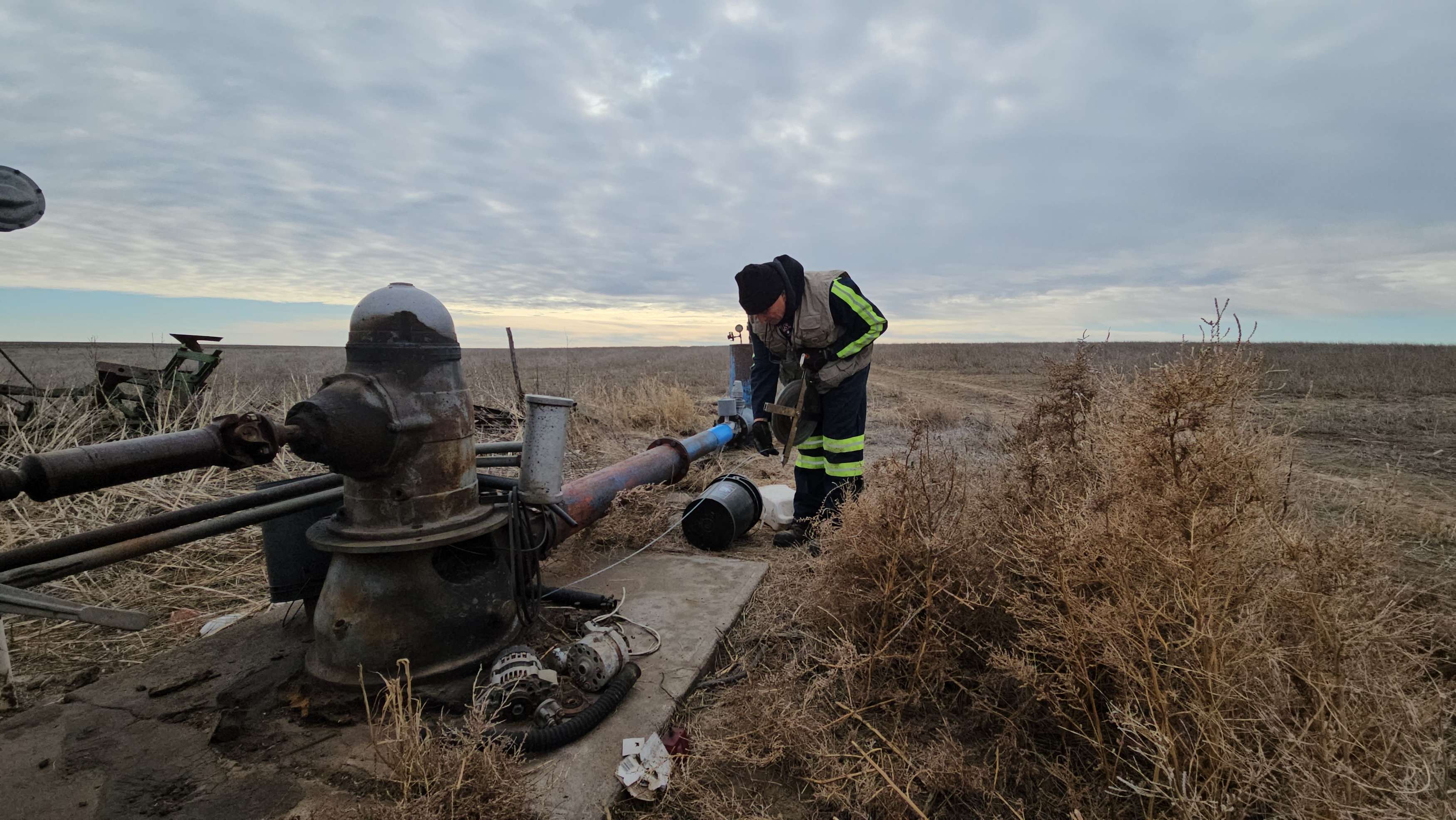 Rick Miller of the Kansas Geological Survey measures water levels in a well south of Oakley in Logan County. Photo by Kansas Geological Survey