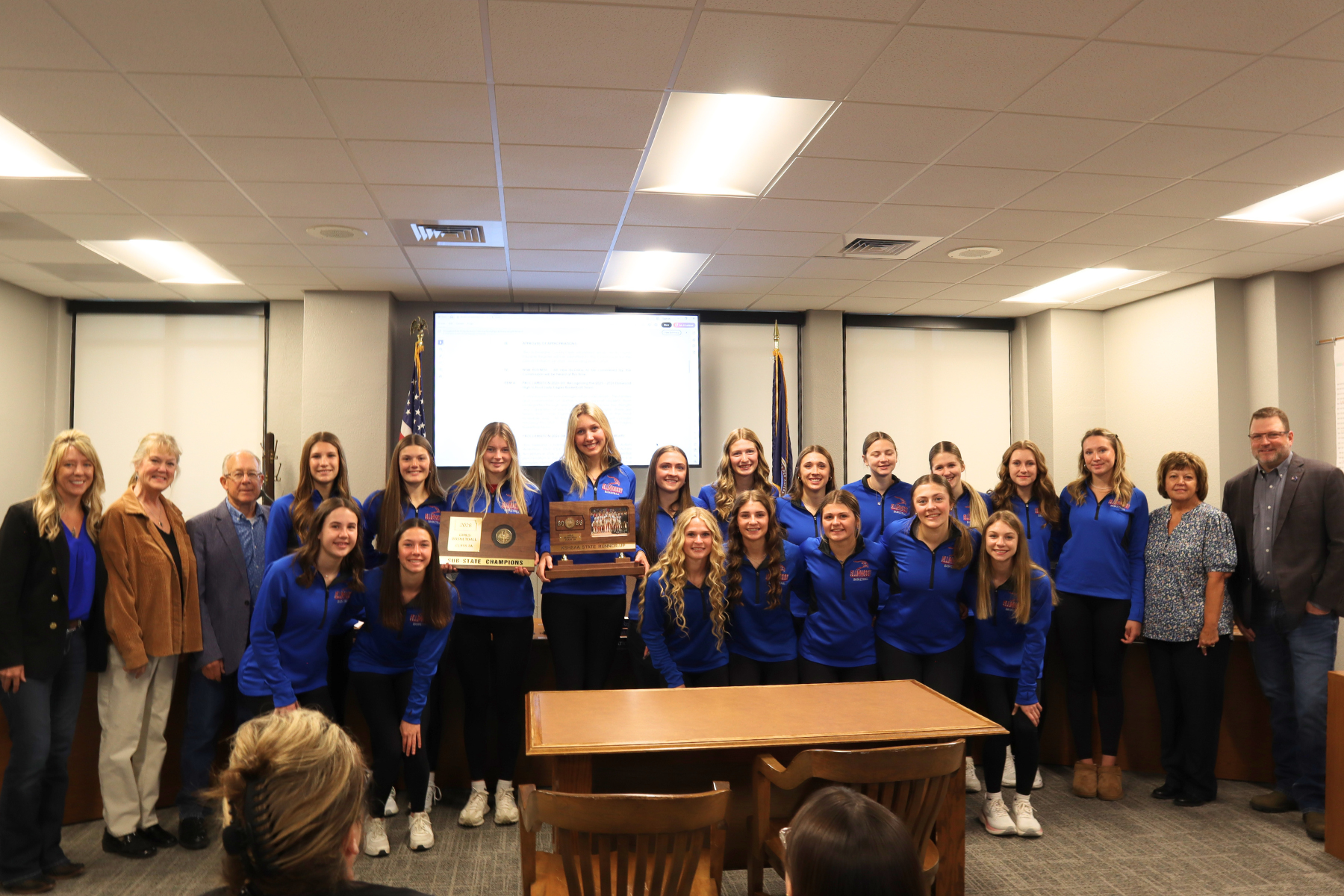 The Ellinwood Lady Eagles basketball team stands with Commissioners following recognition  of their historic season.