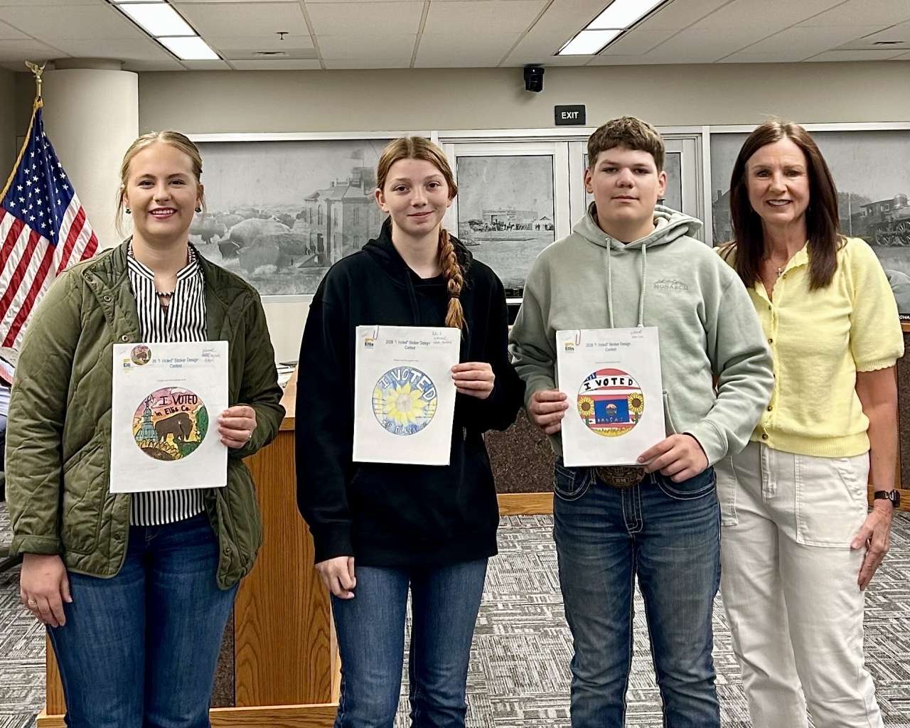 Hays High School senior Mary Vajnar, Victoria High School freshman Kattie Haddock and Victoria High School sophomore Colin Lee pose with their winning "I Voted" sticker designs alongside Ellis County Clerk Bobbi Dreiling. Courtesy photo
