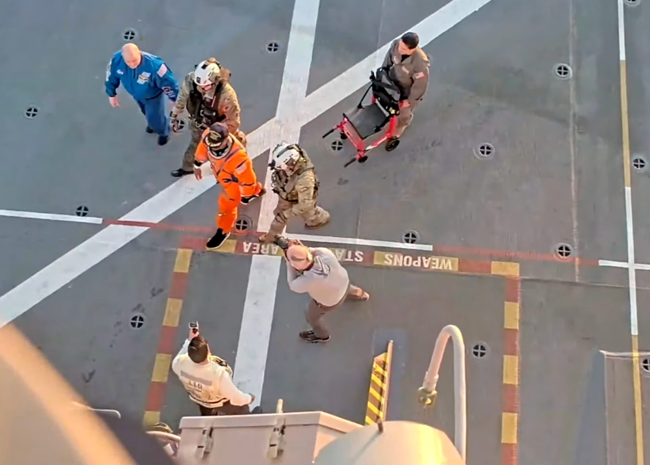 Artemis II pilot Victor Glover walks from the recovery helicopter to a medical suite aboard the recovery ship -image from NASA video