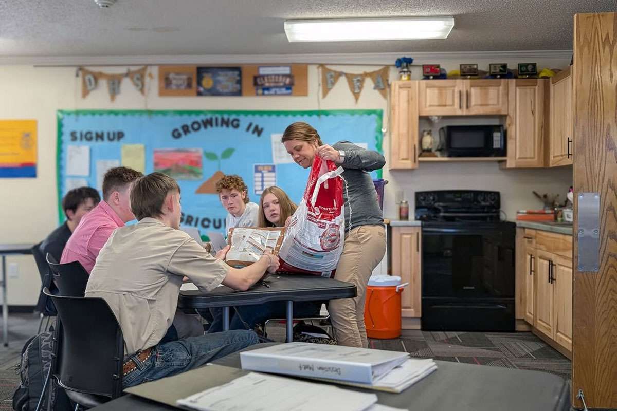 Chelsy Champlin, a graduate student in K-State's online master's program in agricultural education and teacher at Dexter High School, gives a lesson to a table of students. (Photo courtesy K-State News and Communications)