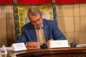 Nebraska Gov. Jim Pillen signs off on the 2024 general election results on Monday, Dec. 2, 2024. (Zach Wendling/Nebraska Examiner)