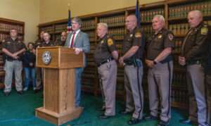 Nebraska Attorney General Mike Hilgers, center, leads a news conference against Legislative Bill 677 that seeks to help implement medical cannabis regulations in the state. About a dozen law enforcement officials joined him in standing against the legislation as it awaits full legislative debate. May 7, 2025. (Zach Wendling/Nebraska Examiner)