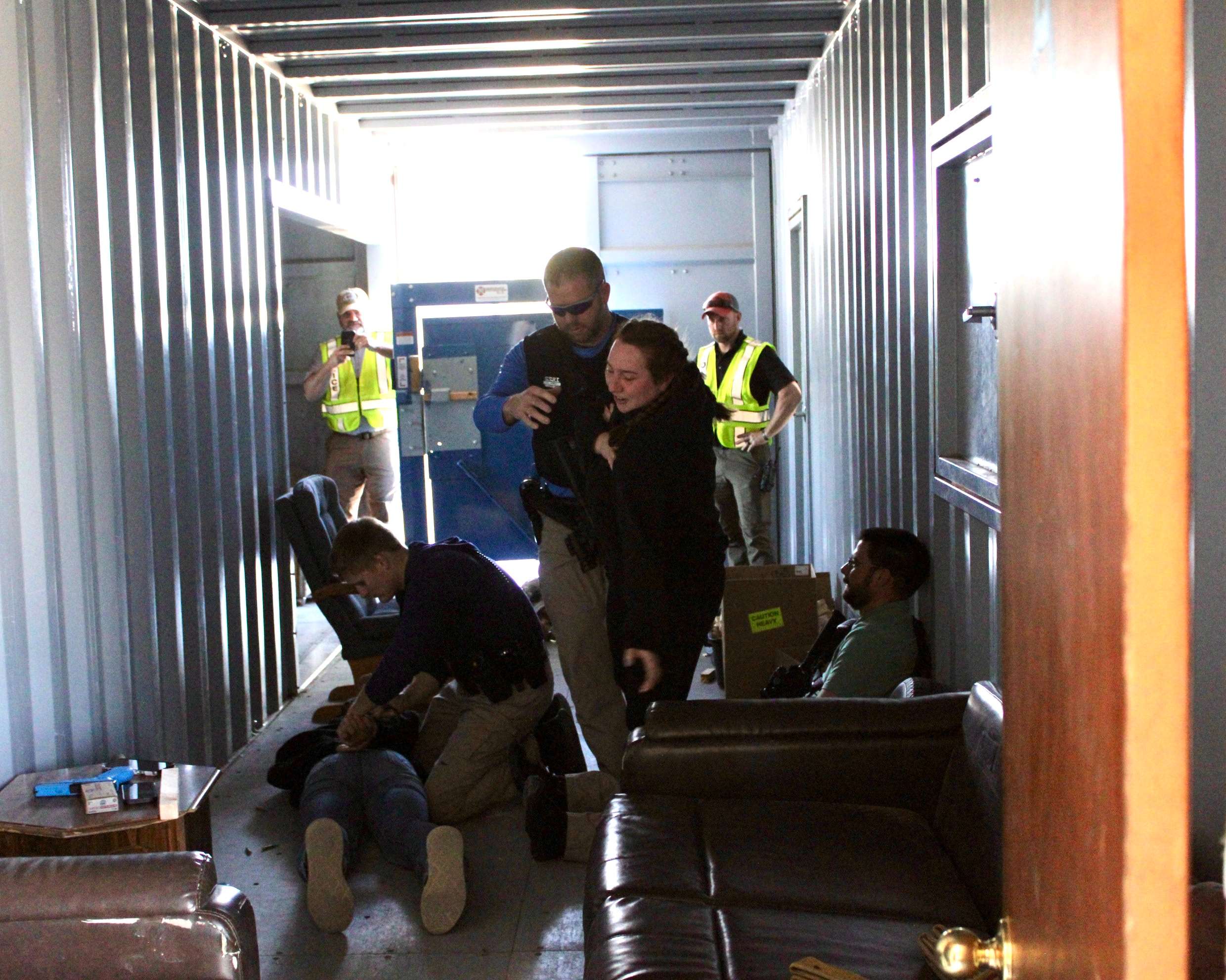 Hays police officers taking two role-players into custody after entering a room where a domestic altercation had occurred for training purposes. Photo by Tony Guerrero/Hays Post