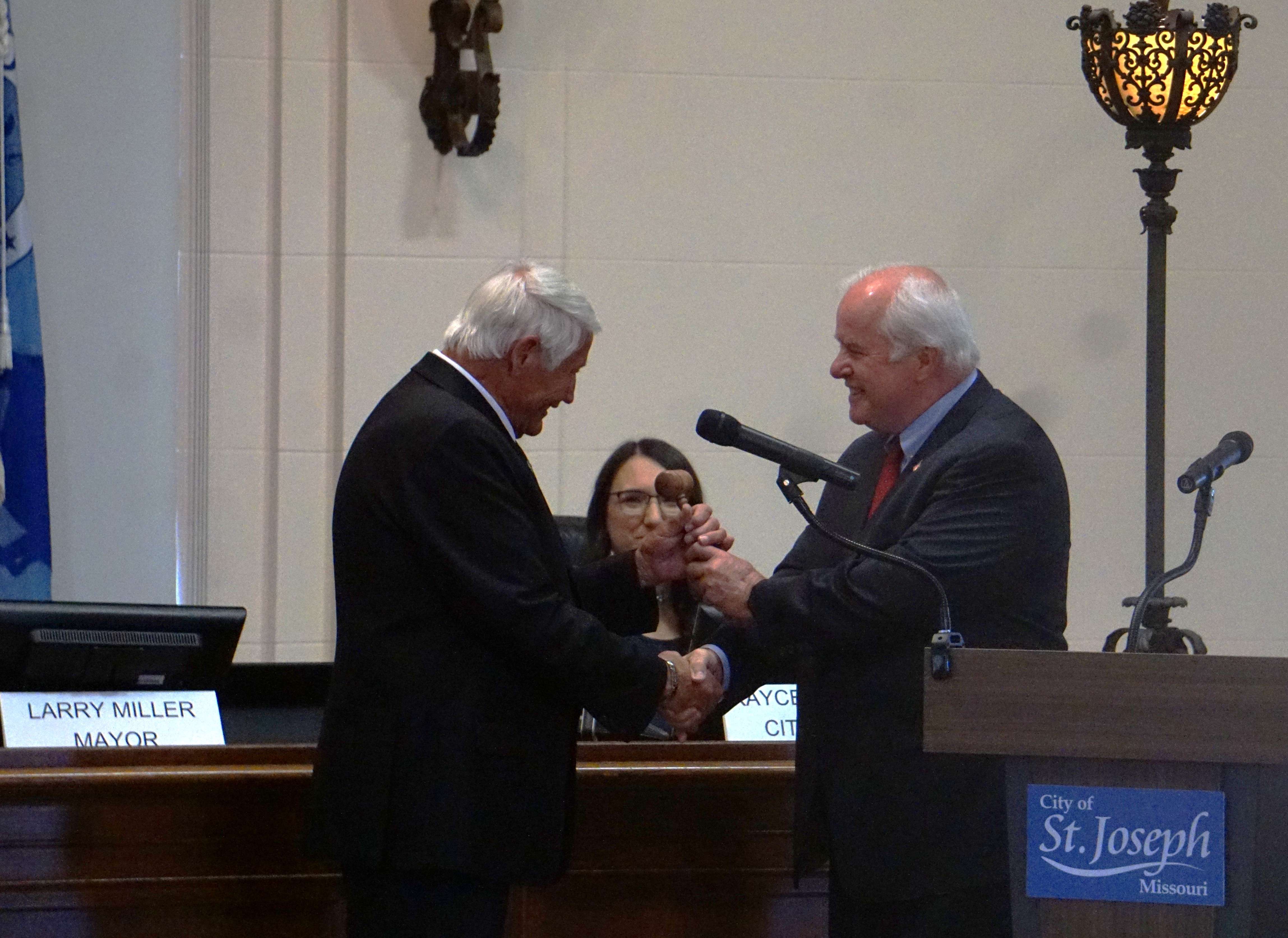 Outgoing Mayor John Josendale passes on the gavel to new Mayor Larry Miller/ Photo by Matt Pike