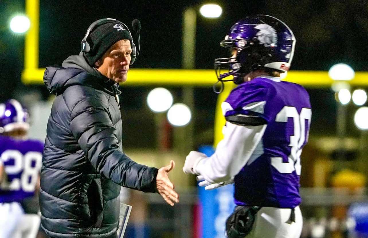 Coach Gebhardt shakes hands with Grady Gebhardt following a touchdown in a state win over Nemaha Central. Photo by Tanner Colvin.