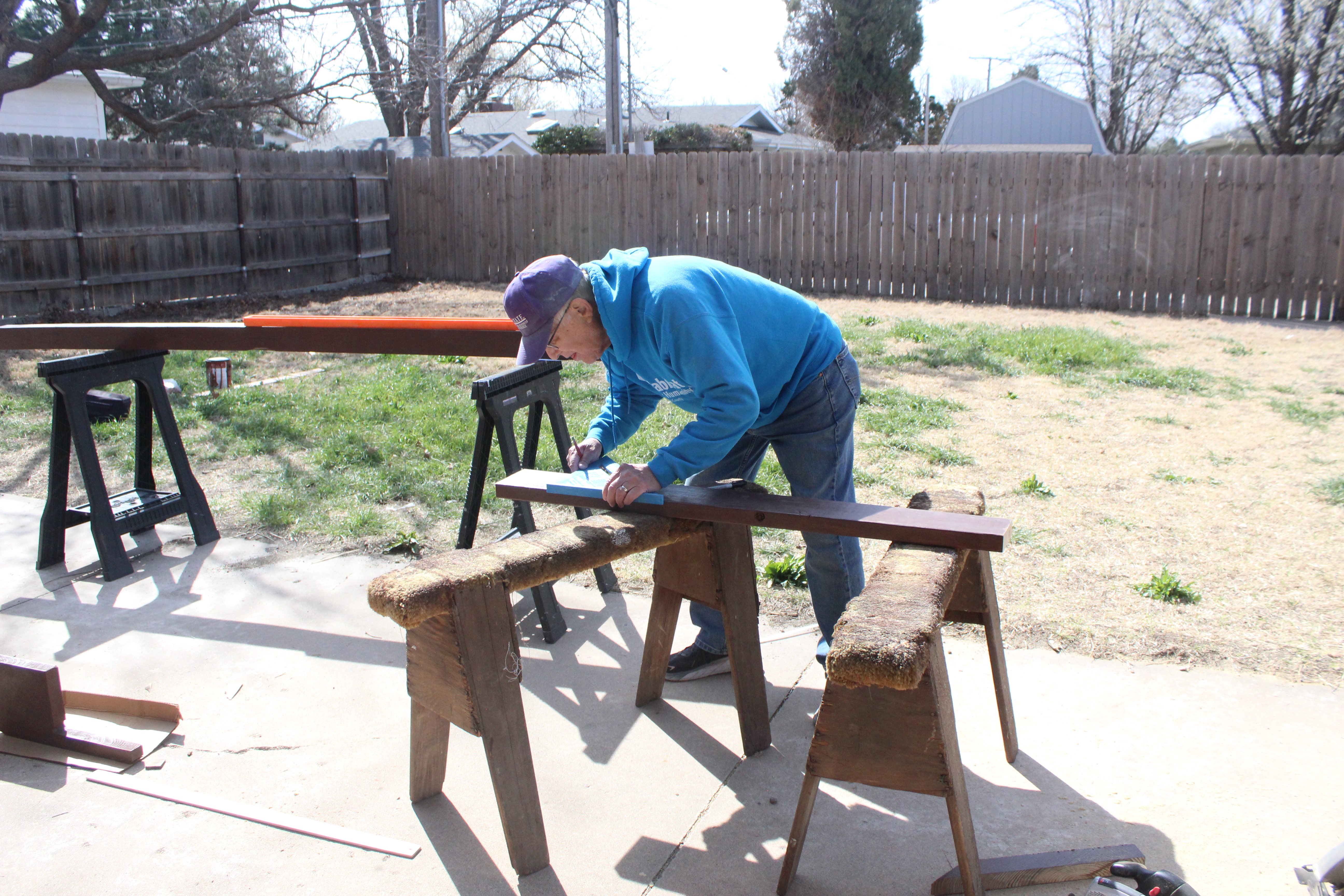 Phil Stahlman, Habitat volunteer and project leader, cuts a board to size for a stair repair project. Ellis County residents with qualifying projects and incomes can apply for help with home repairs through Habitat. Photo by Cristina Janney/Hays Post<br>