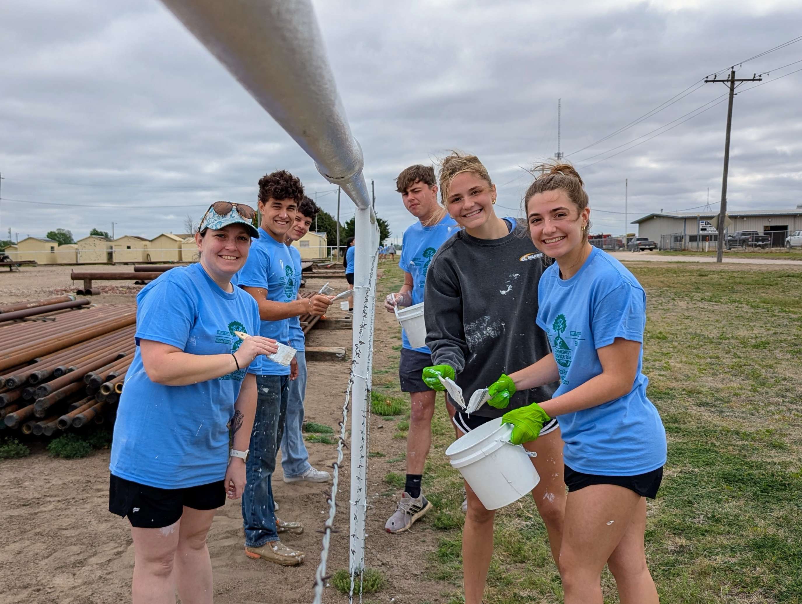 Great Bend High School students, joined by their teacher, Mrs. Schiffelbein, apply a fresh coat of paint to a large pipe fence at Smith Supply LLC on Wednesday morning. Two groups of students, about 24 in all, worked throughout the day as part of GBHS’s Community Service Day initiative.