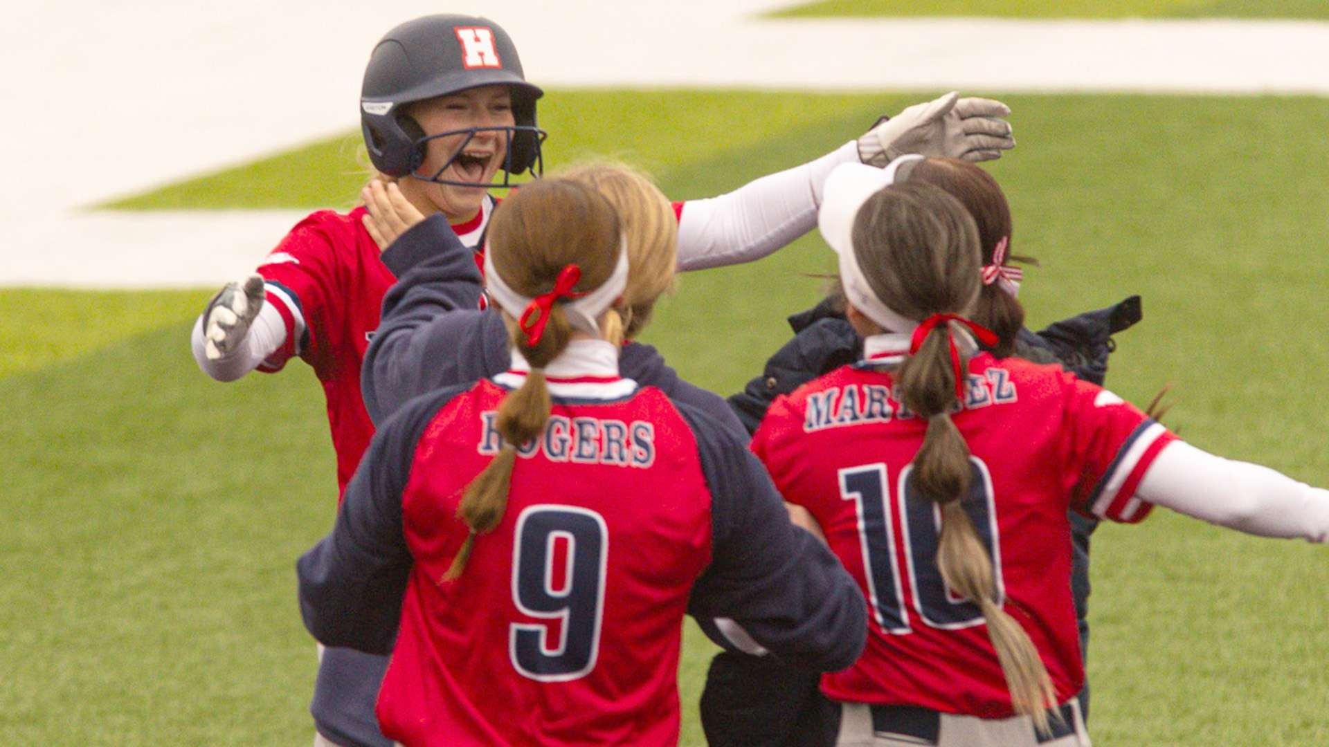 Blue Dragon teammates rush out to celebrate with Hadley Topping, who it a walk-off single in Hutchinson's 2-1 Game 1 victory over Garden City on Wednesday at Fun Valley. (Sydney Holzrichter/Blue Dragon Sports Information)
