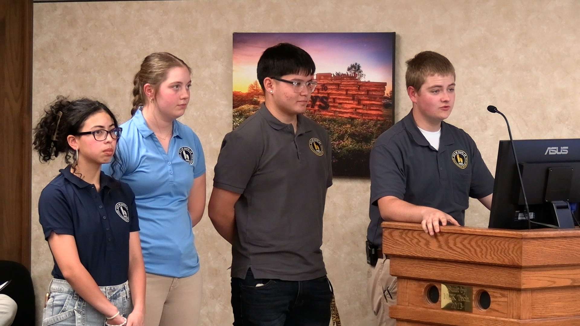 Members of the 2025-2026 Hays Youth Leadership Advisory Board Elliana Pineda, Hays High School; Jenna Brull, secretary, Thomas More Prep-Marian High School; Mario Hernandez, Hays High School; and Preston Mermis, president, Thomas More Prep-Marian High School; speak to the Hays City Commission at the April 24 meeting. Photo by Becky Kiser/Hays Post