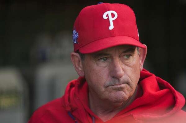 Philadelphia Phillies manager Rob Thomson (49) stands in the dugout before a baseball game against the Chicago Cubs, Wednesday, April 22, 2026, in Chicago. (AP Photo/Erin Hooley)