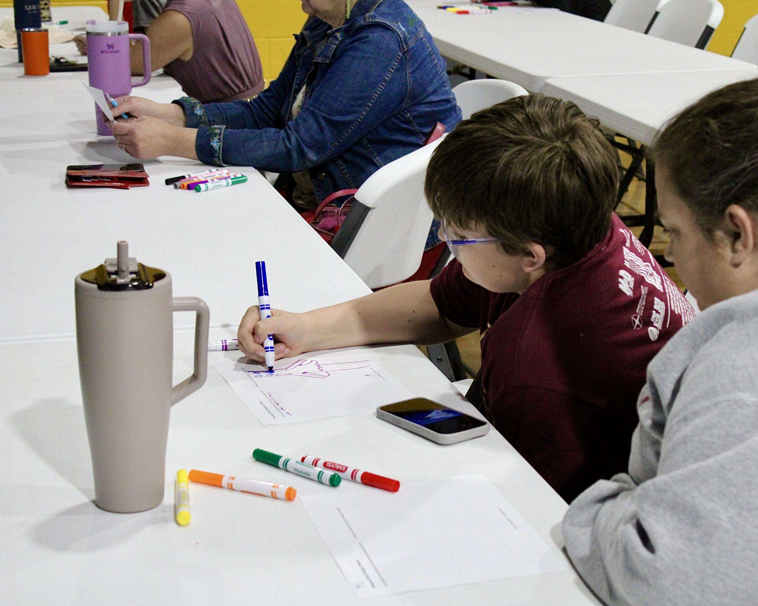 A young attendee drawing his own mission patch. Photo by Tony Guerrero/Hays Post