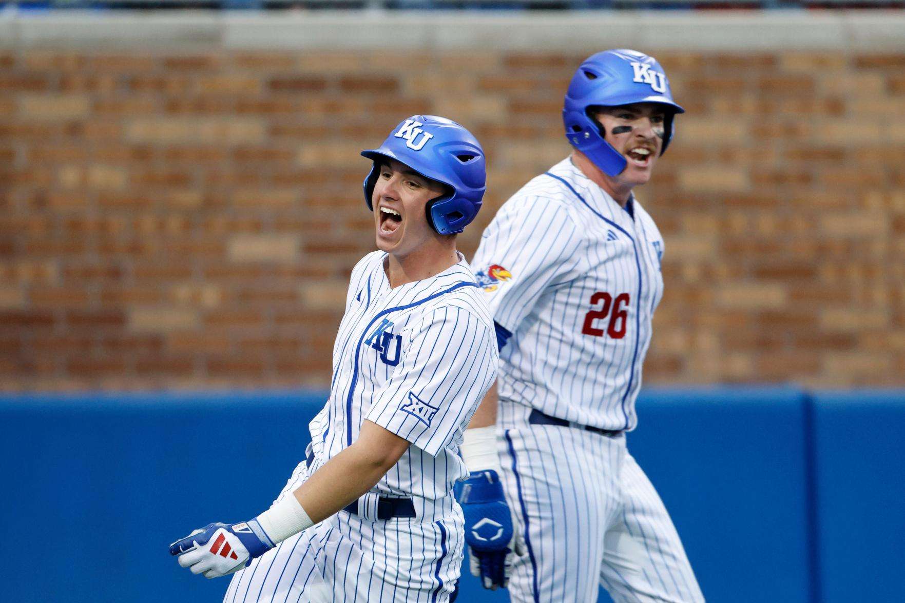 Kansas' Tyson LeBlanc, left, and Brady Ballinger (26) react after scoring off a Dariel Osoria single during eighth inning of an NCAA college baseball game against St. Thomas on March 5, 2026, in Lawrence, Kan. (AP Photo/Colin E. Braley, file)