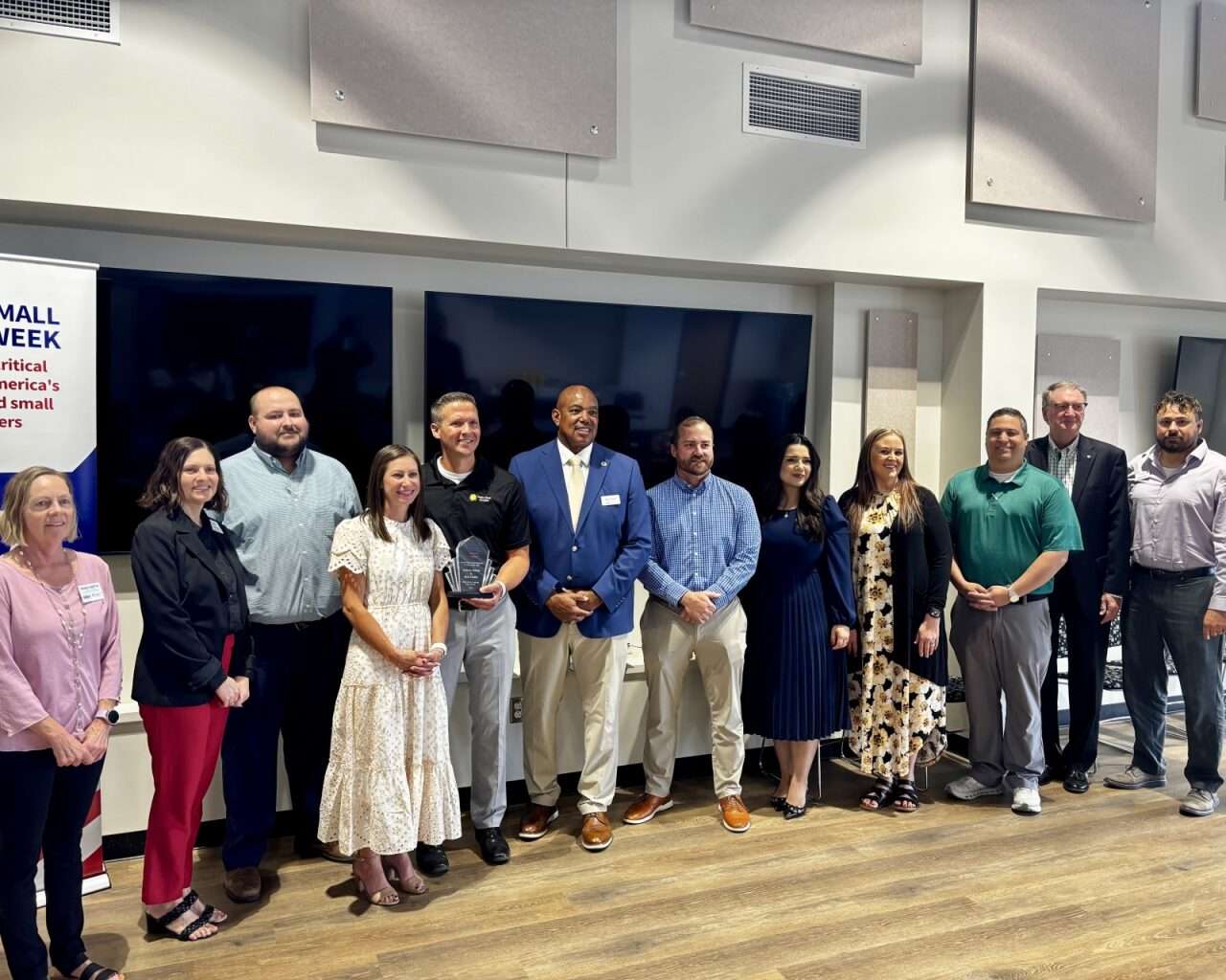 Bright Minds Academy in Hays co-Founders Andrea and Nick Felder with their National Small Business Week award, surrounded by officials and community partners. Photo by Tony Guerrero/Hays Post