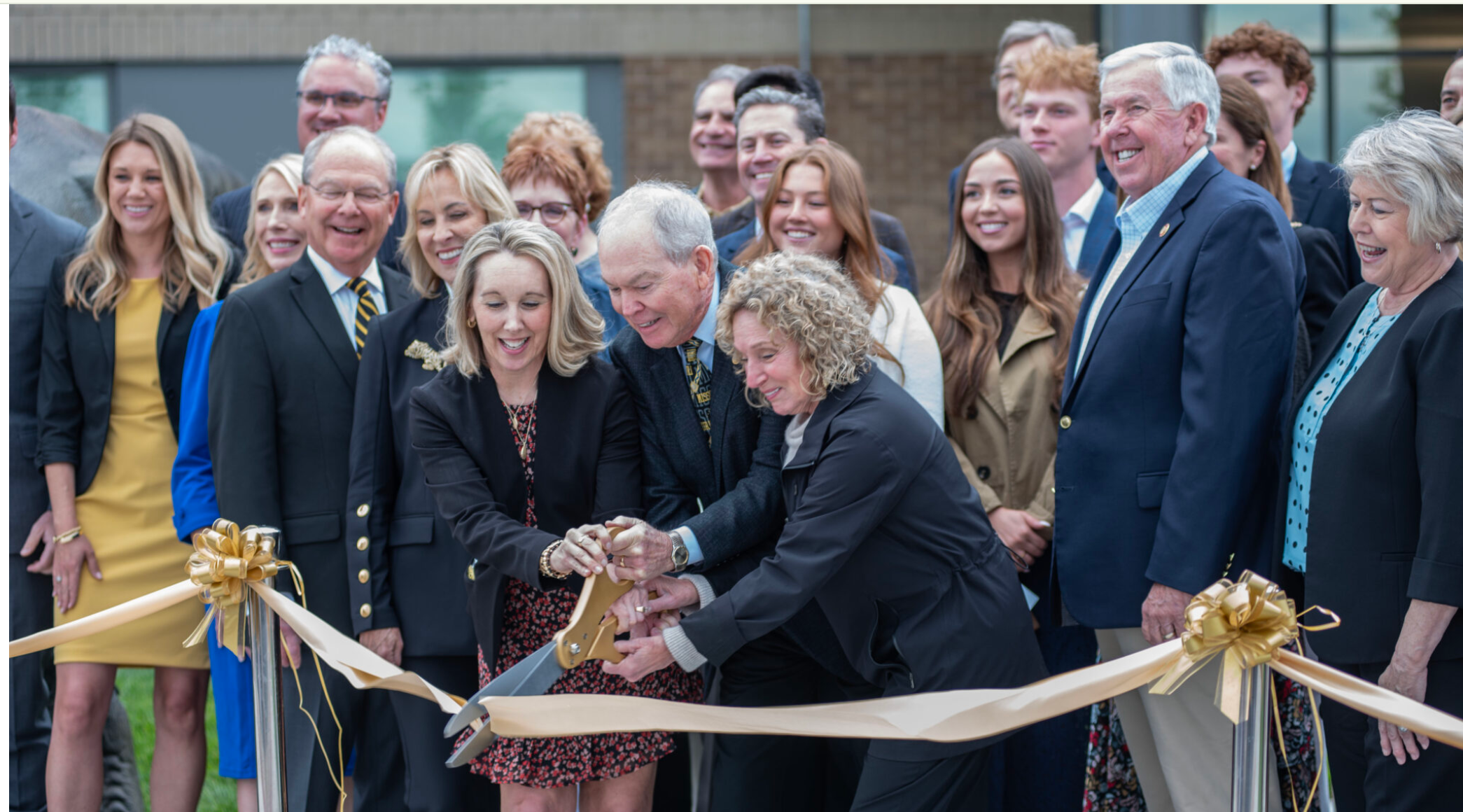  The Thompson Center for Autism and Neurodevelopment executive director Connie Brooks cuts a ceremonial ribbon with the center’s founders Bill and Nancy Thompson to open a new building in Columbia on Friday. State officials, such as former governor Mike Parson, joined in the celebration (Annelise Hanshaw/Missouri Independent).
