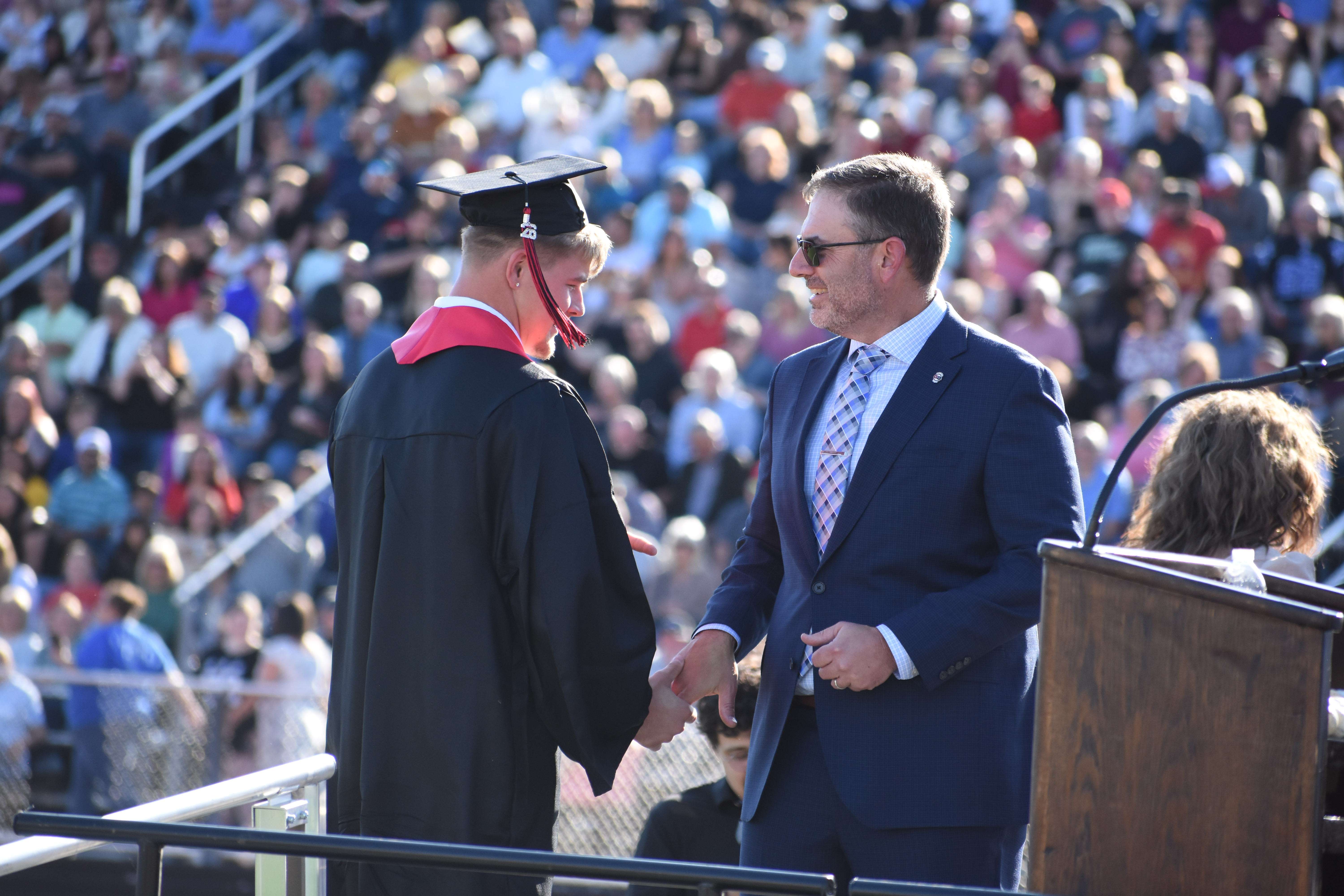 Triston Tomlinson shakes hands with USD 428 Superintendent Khris Thexton on his trip across the stage.