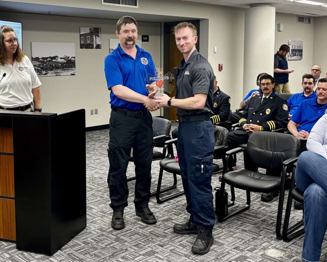 Firefighter Matt VanDyke handing EMT Dawson VonFeldt an EMS Field Save Award during the Ellis County Commission meeting on Tuesday. Photo by Tony Guerrero/Hays Post