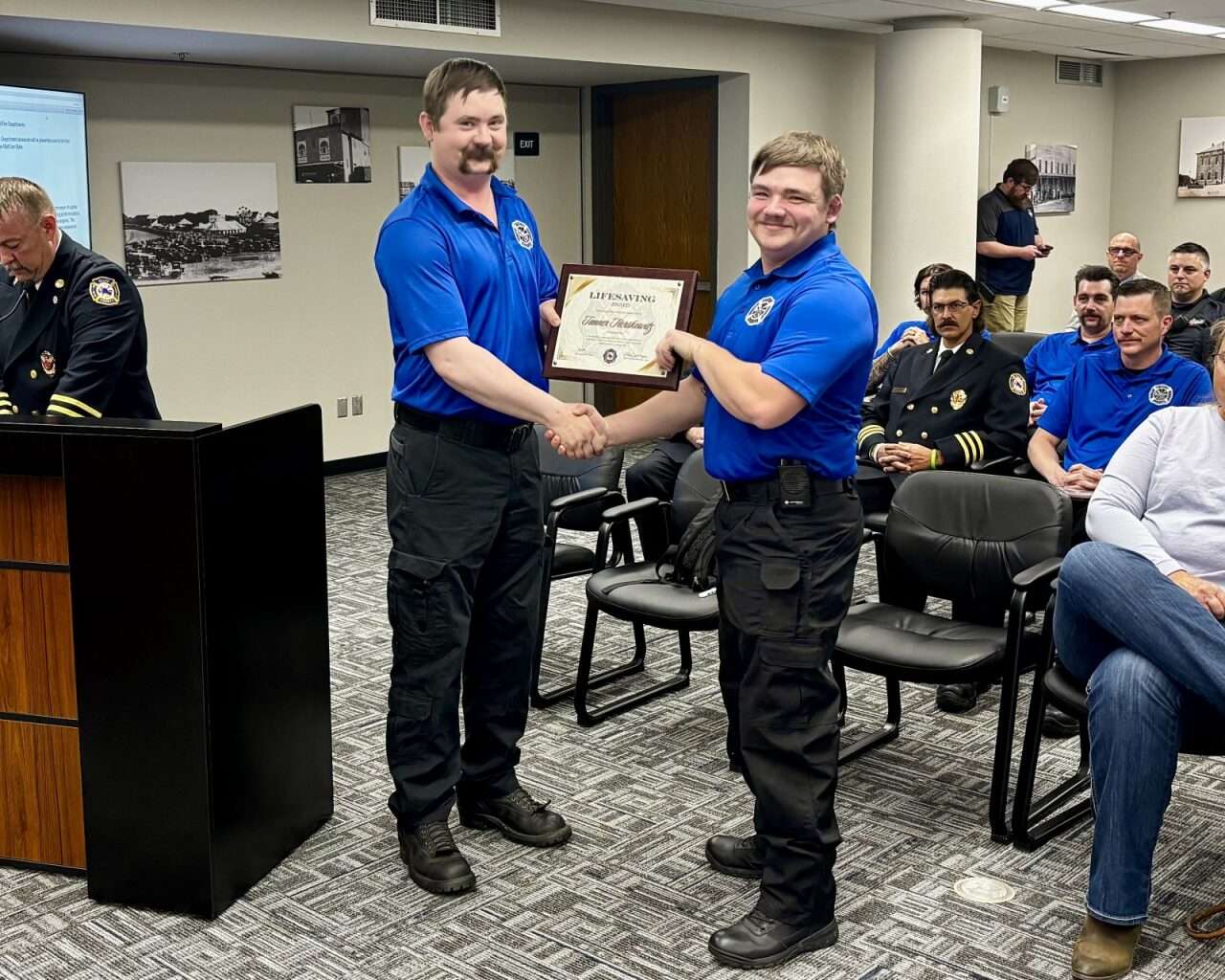 Firefighter Matt VanDyke handing firefighter&nbsp;Tanner Herskowitz a Lifesaving Commendation Award. Photo by Tony Guerrero/Hays Post