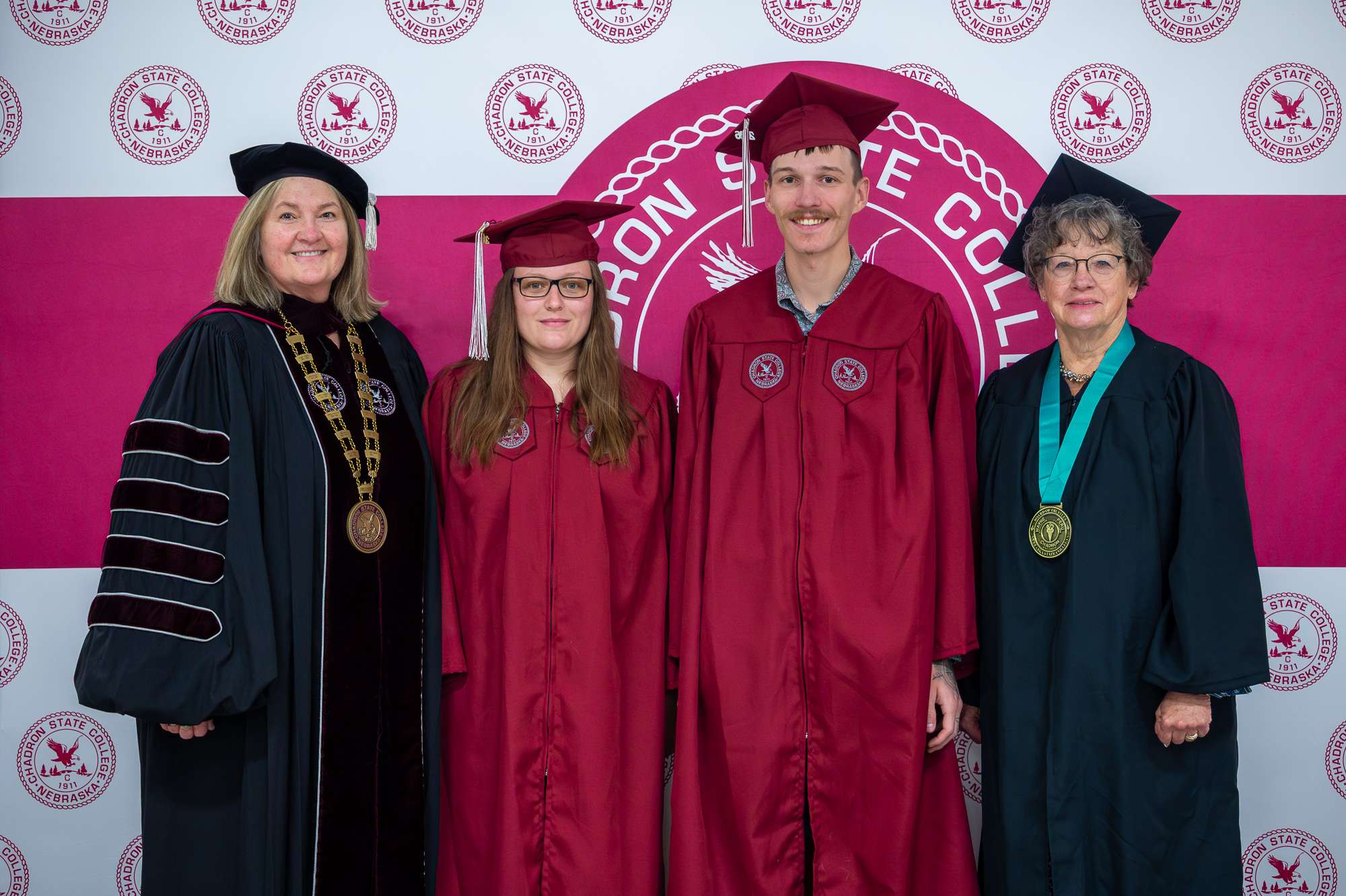 Chadron State College President Dr. Jodi Kupper poses with Associate of General Studies graduates Abbagale Serl of Alliance Neb., and Austin Kennedy of Crawford, Neb., along with Marjean Terrell, Vice Chair of the Nebraska State College System Board of Trustees at CSC Commencement May 8, 2026, in the Chicoine Center. (Photo by Sydney Brown/Chadron state College)