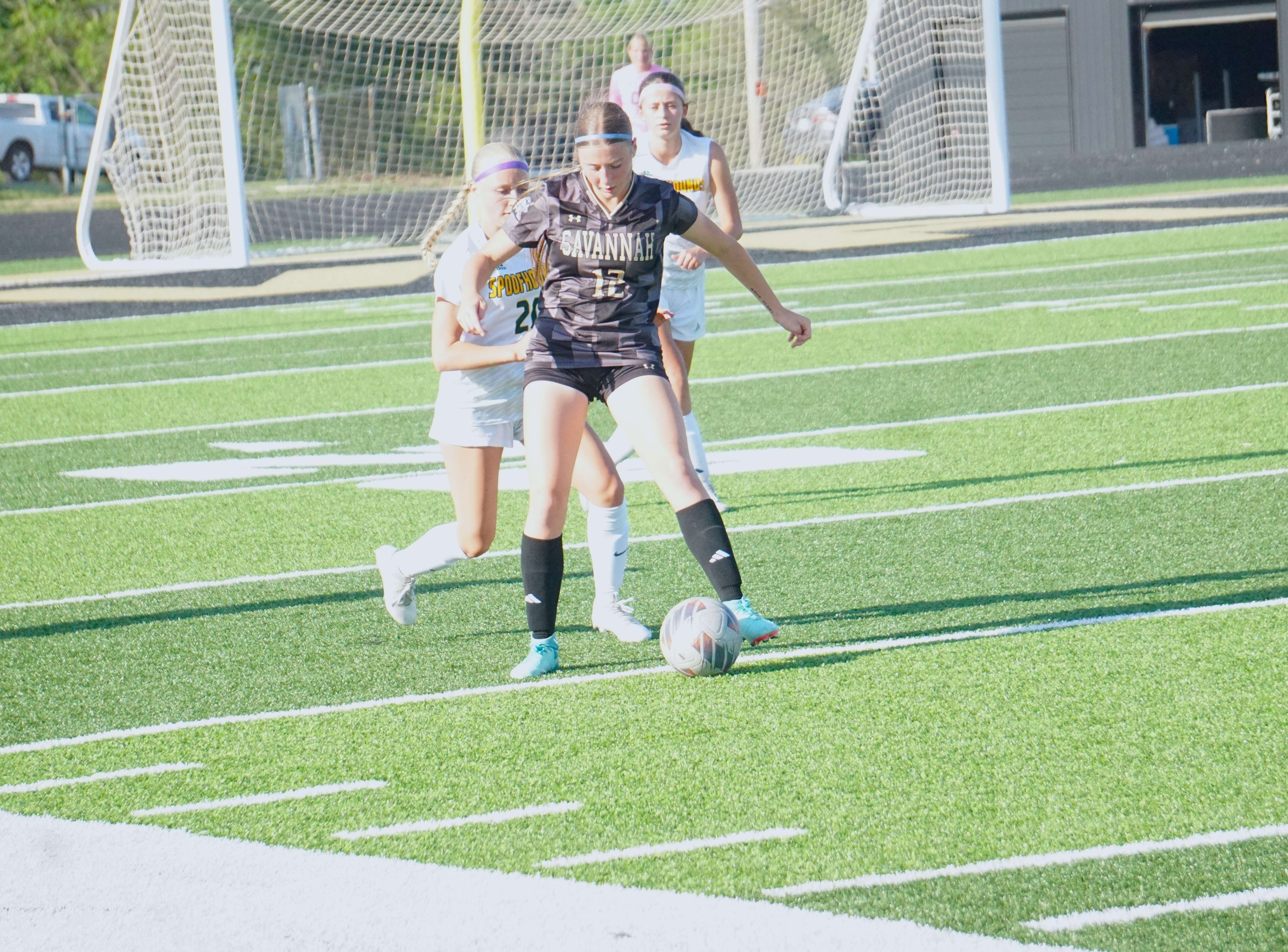 Lily Musser (12 works to get the ball around a defender/ Photo by Matt Pike