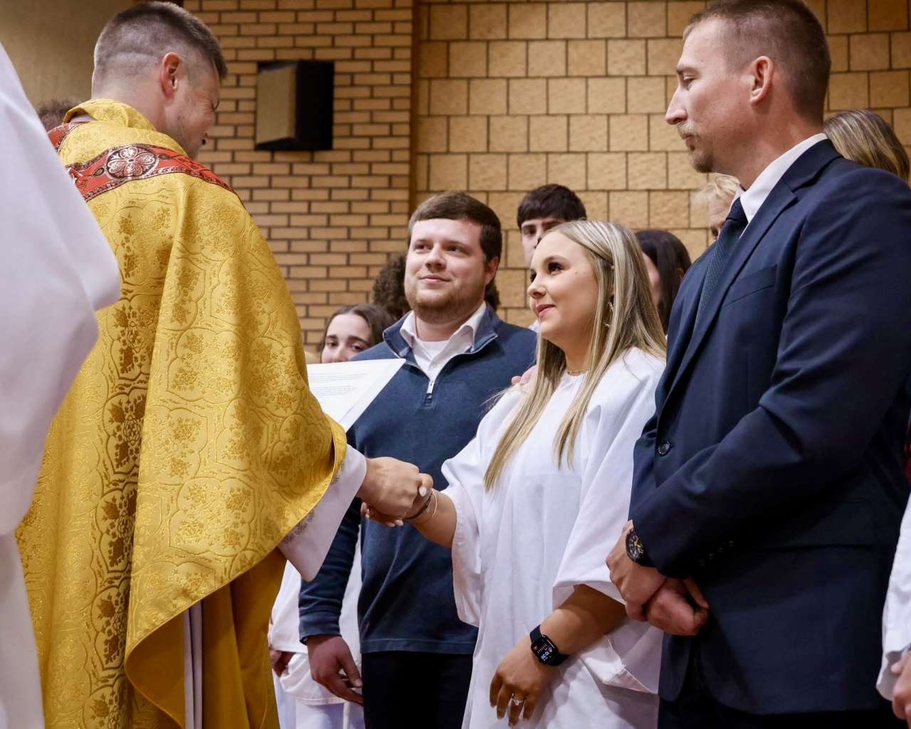 The Rev. Andy Hammeke welcomed 13 new members to the Catholic Church at the 2025 Easter Vigil Mass. Courtesy photo