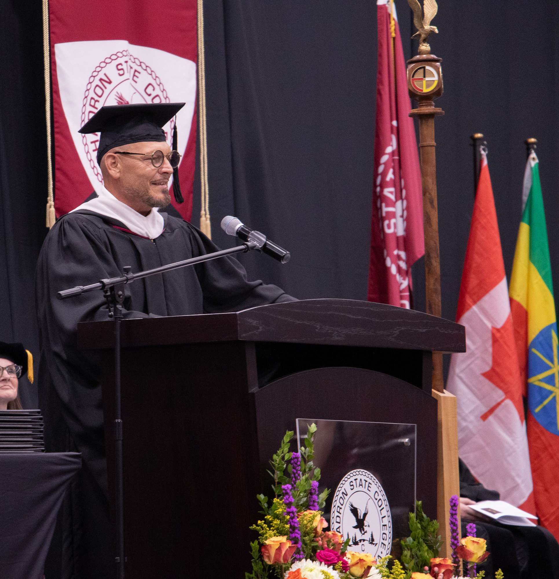 Commencement speaker and Chadron State College graduate Shawn Banzhaf addresses the graduate May 8, 2026, in the Chicoine Center. (Photo by Tena L. Cook/Chadron State College)