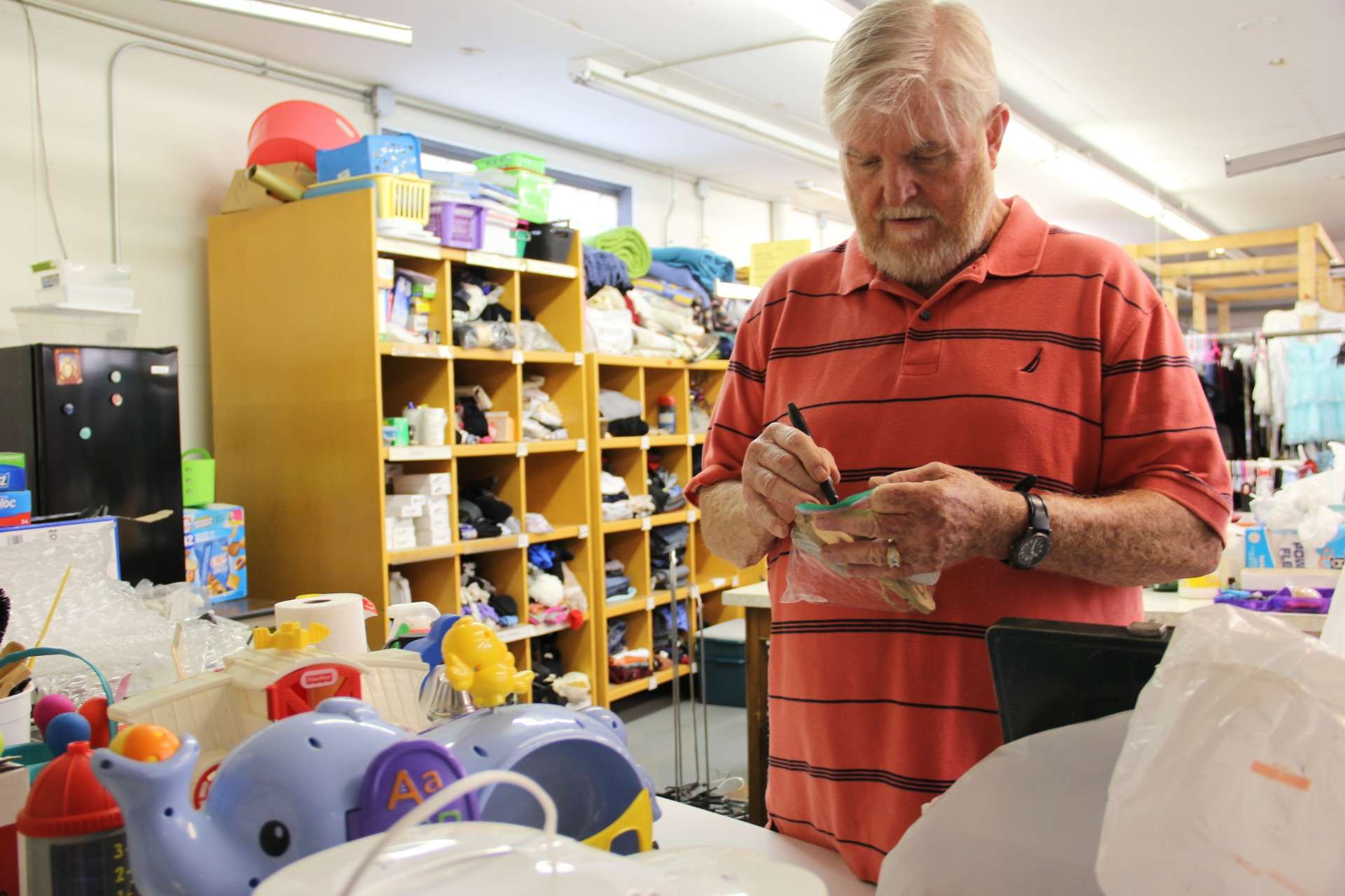 Tim, CCNK Salina Thrift Store volunteer checking donated items to ensure they work and all of the pieces are there - Photo, Catholic Charities of Northern Kansas