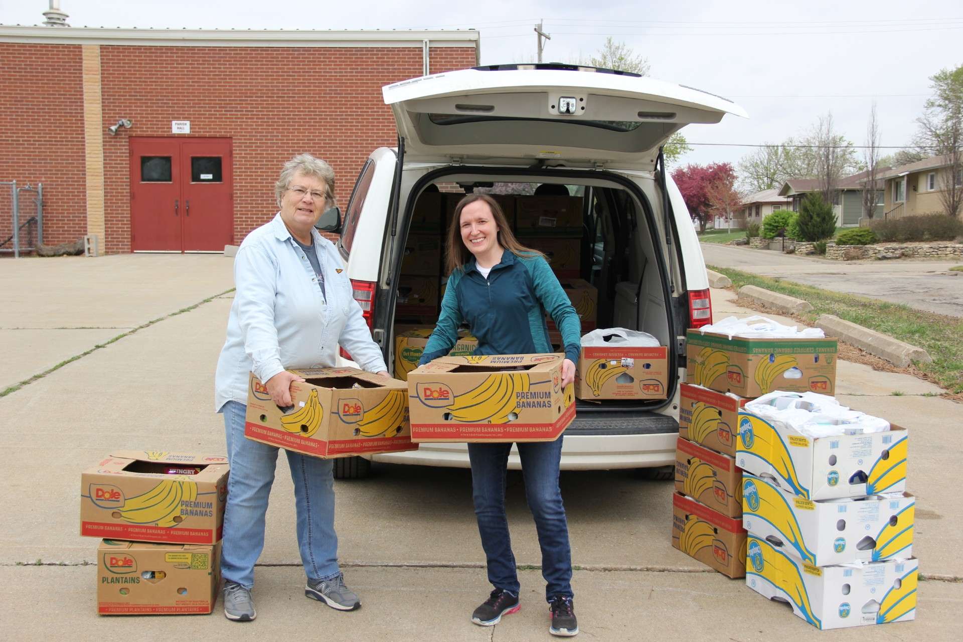 Two local volunteers from the parish in Herington, Kansas, help unload the Catholic Charities outreach van for distribution -&nbsp;Photo, Catholic Charities of Northern Kansas