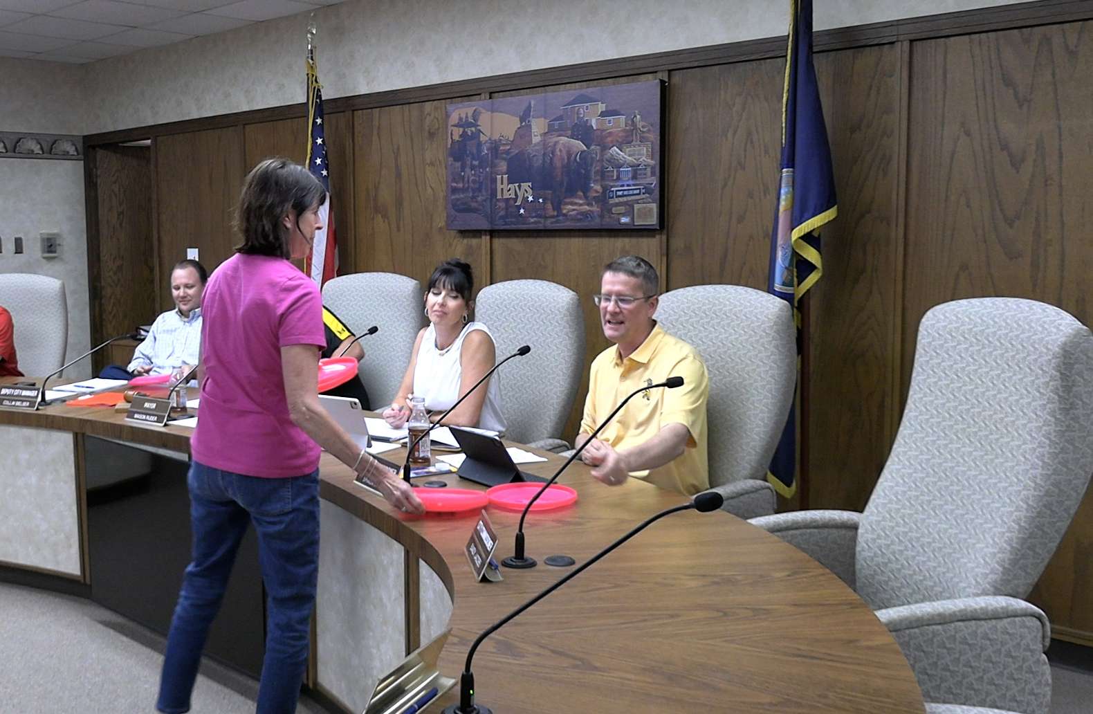 Mary Ann Shorman, Women Who Lead member, hands out golf discs with the WWL logo to Hays city commissioners at their May 14 meeting. Photo by Becky Kiser/Hays Post