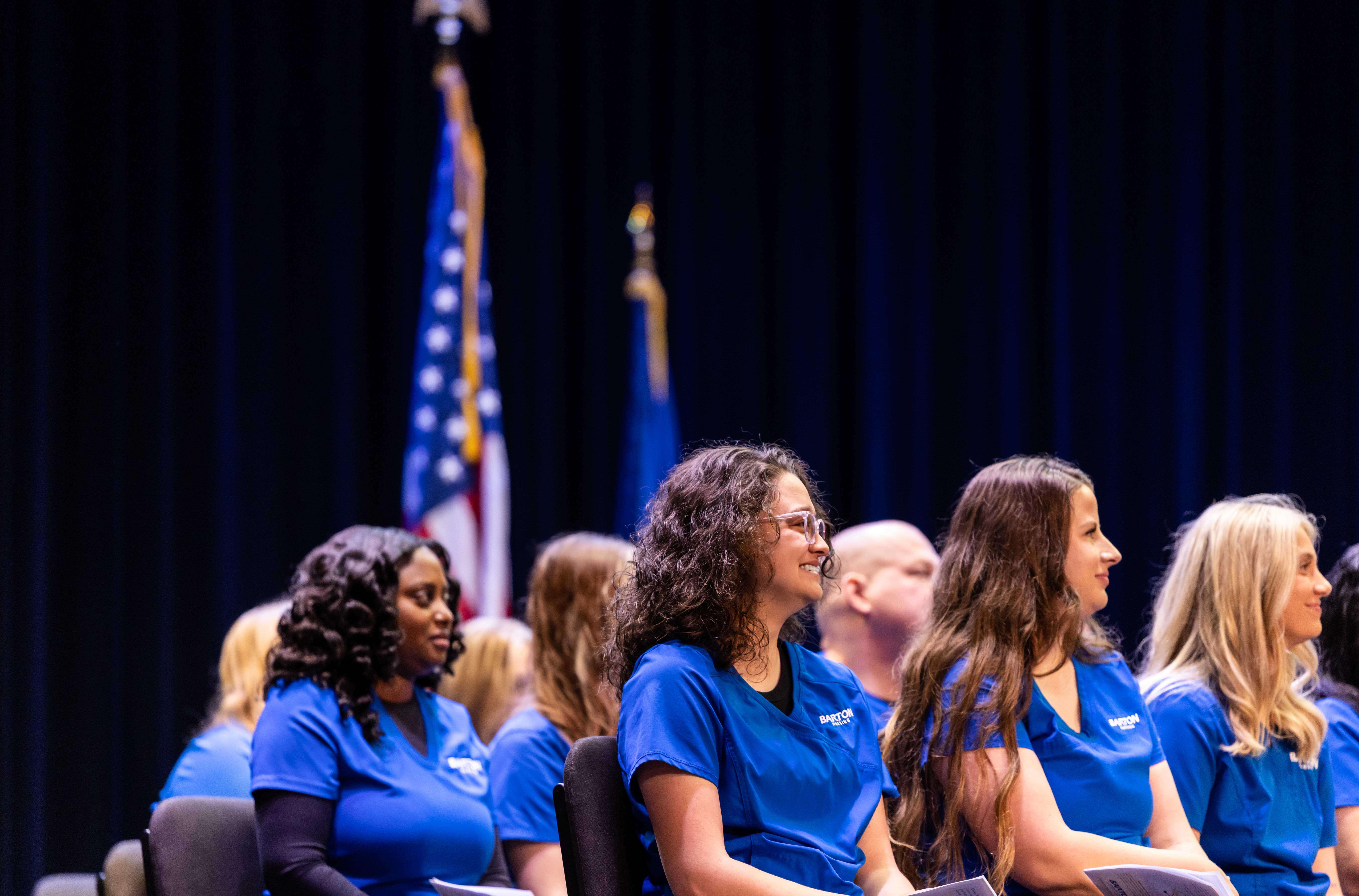 Nursing students look on as program directors speak to the graduates at Friday's nurse pinning ceremonies on the Barton campus.