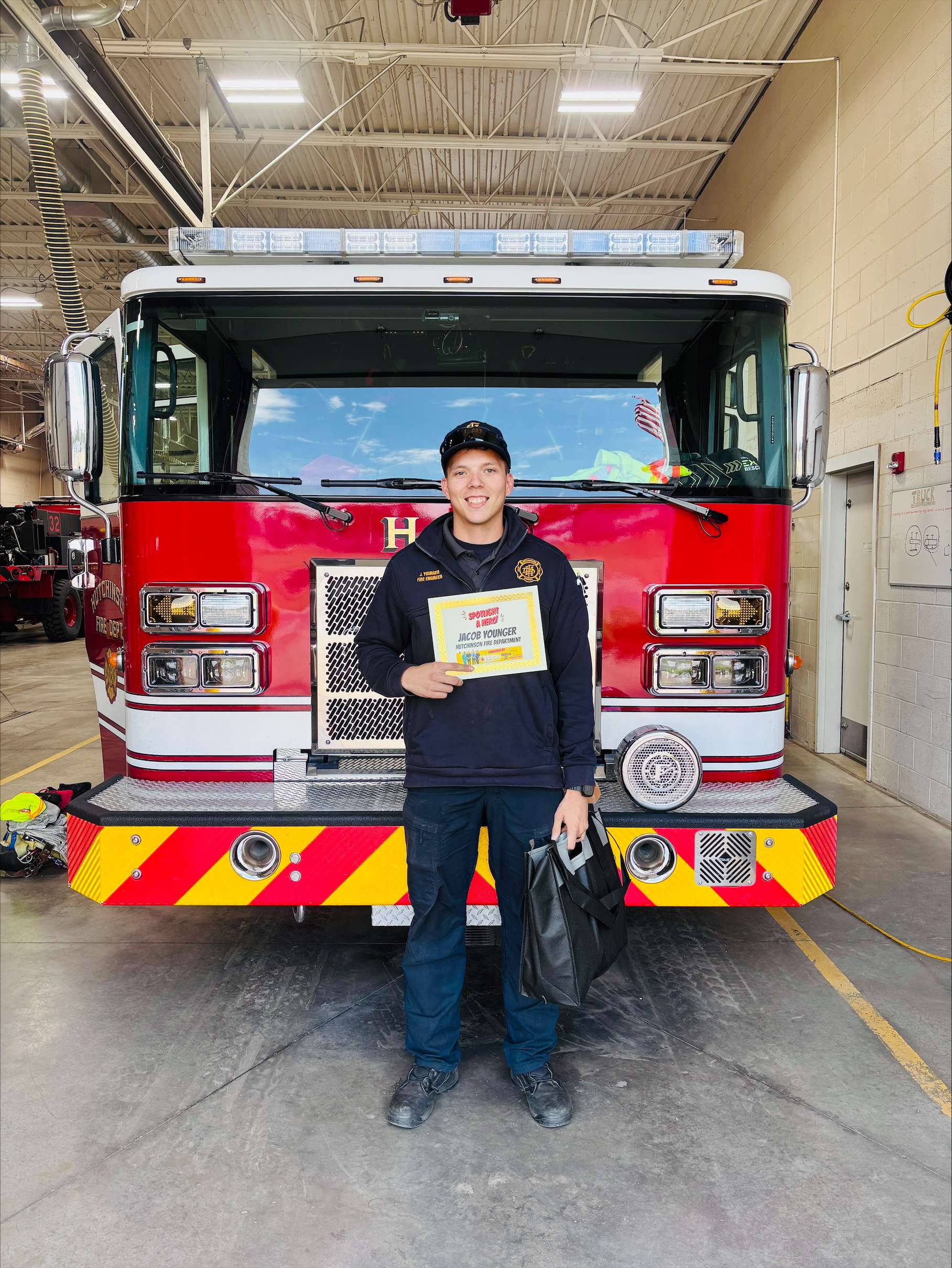 Hutchinson Fire Department firefighter Jacob Younger poses with his certificate after being named the First Responder of the Month for May. The honor is sponsored by PrairieStar Health Center and Eagle Media. Younger also received a gift bag from Smith’s Market. (Hutch Post photo)