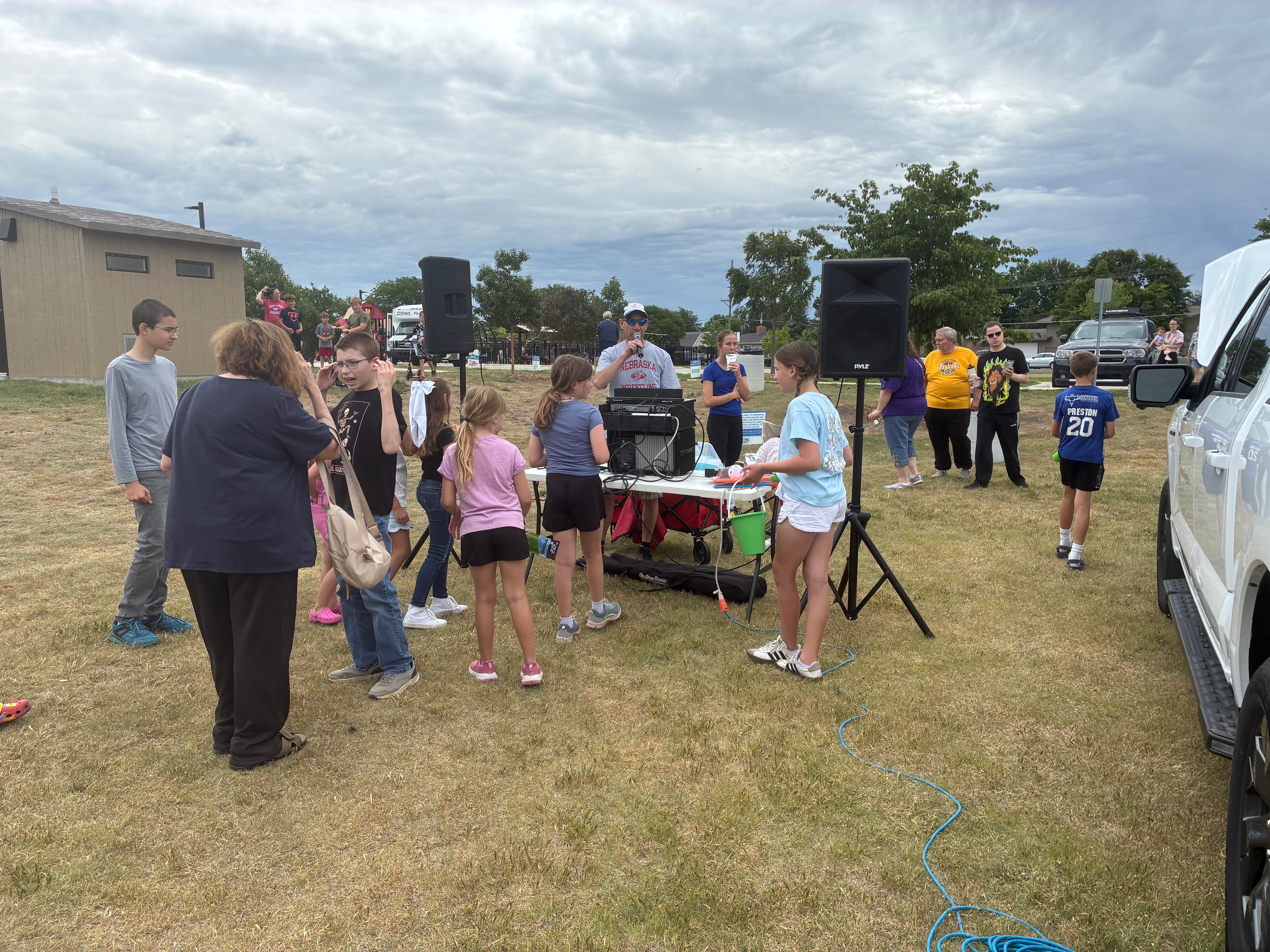 Eagle Radio’s Mike Holliday keeps the crowd entertained , visiting with attendees and giving away summer-themed prizes throughout the afternoon. Photo by Alin Hett/ Hays Post<br>