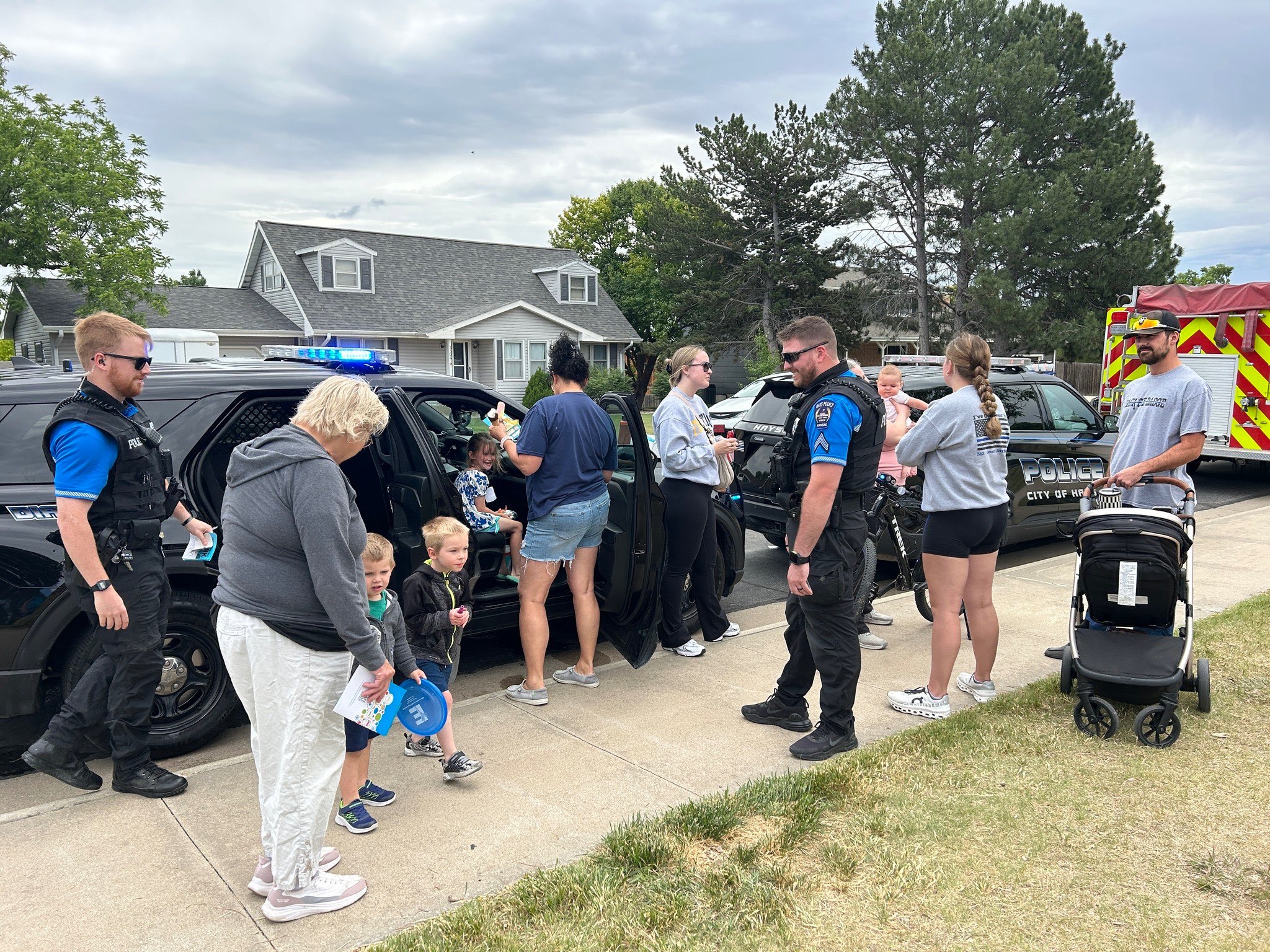 Officer Alex Lenser and Corporal Ethan Henderson of the Hays Police Department give children and families a hands-on look inside a police vehicle. Photo courtesy of Hays CVB. <br>