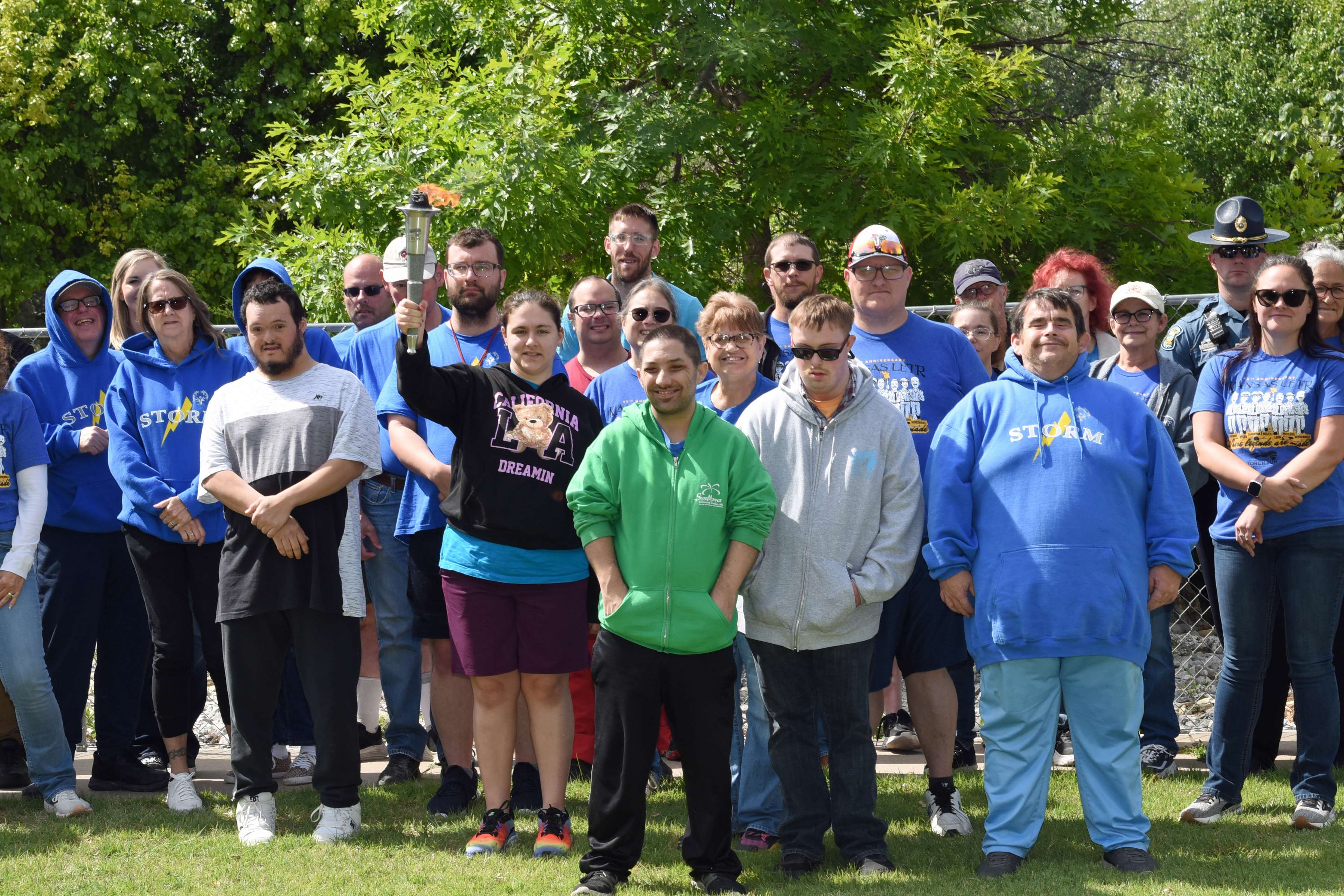 Storm Athlete Caitlyn Stinger proudly holds the “Flame of Hope” Torch among her Storm Team members, along with area Law Enforcement during the Law Enforcement Torch Run in Larned on the morning of May 20.