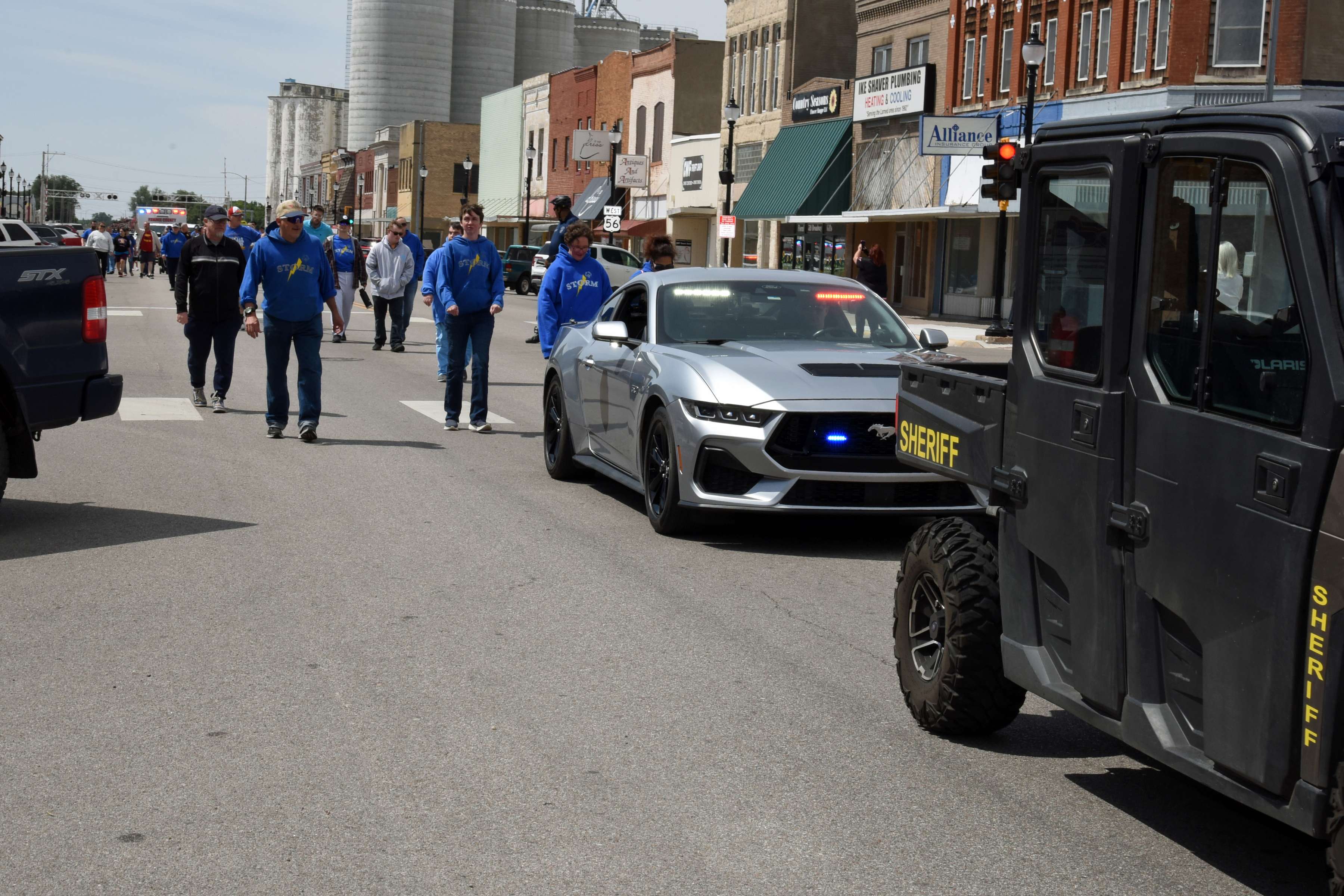 Storm Special Olympics members, along with Pawnee County Law Enforcement agencies and Ellsworth Correctional Facility personnel travel through Broadway in downtown Larned to complete participation in their leg of the Law Enforcement Torch Run on May 20.